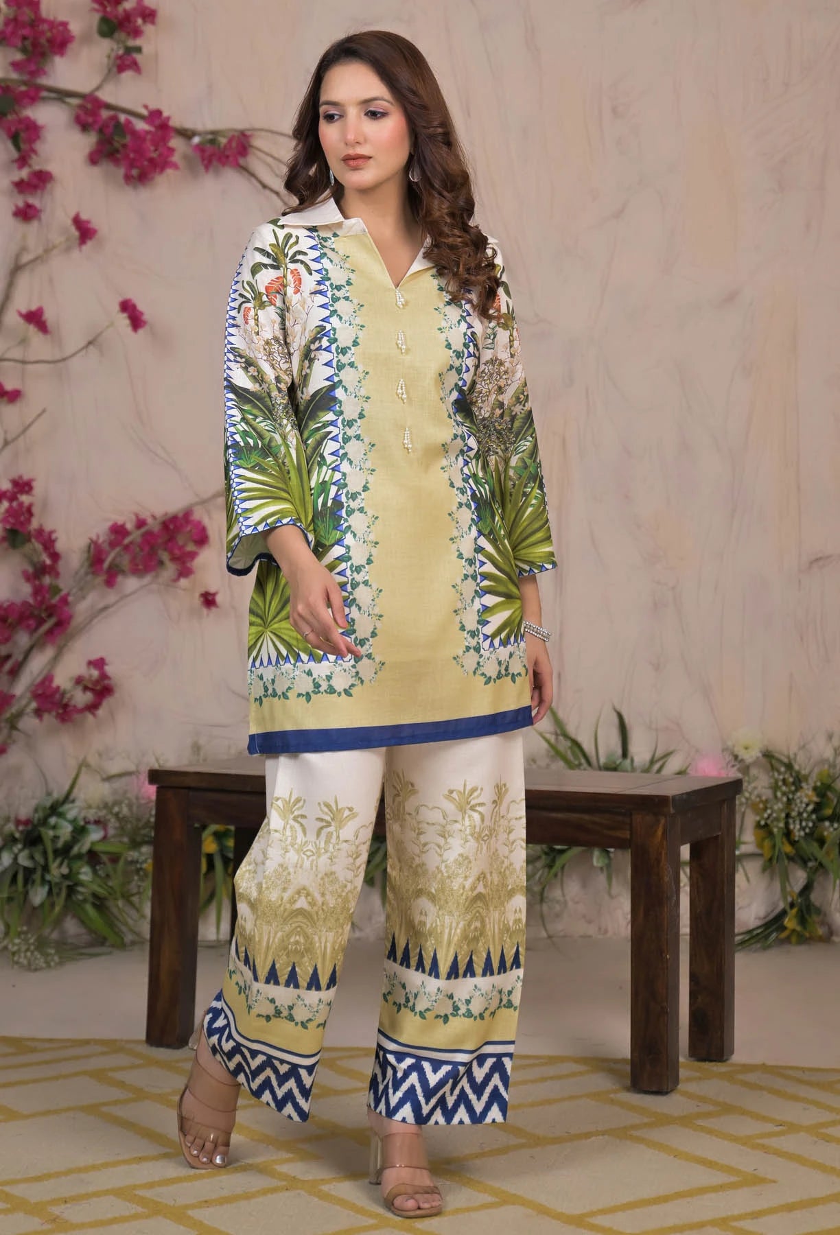 Woman wearing a floral dress with a matching top in a decorated indoor setting.