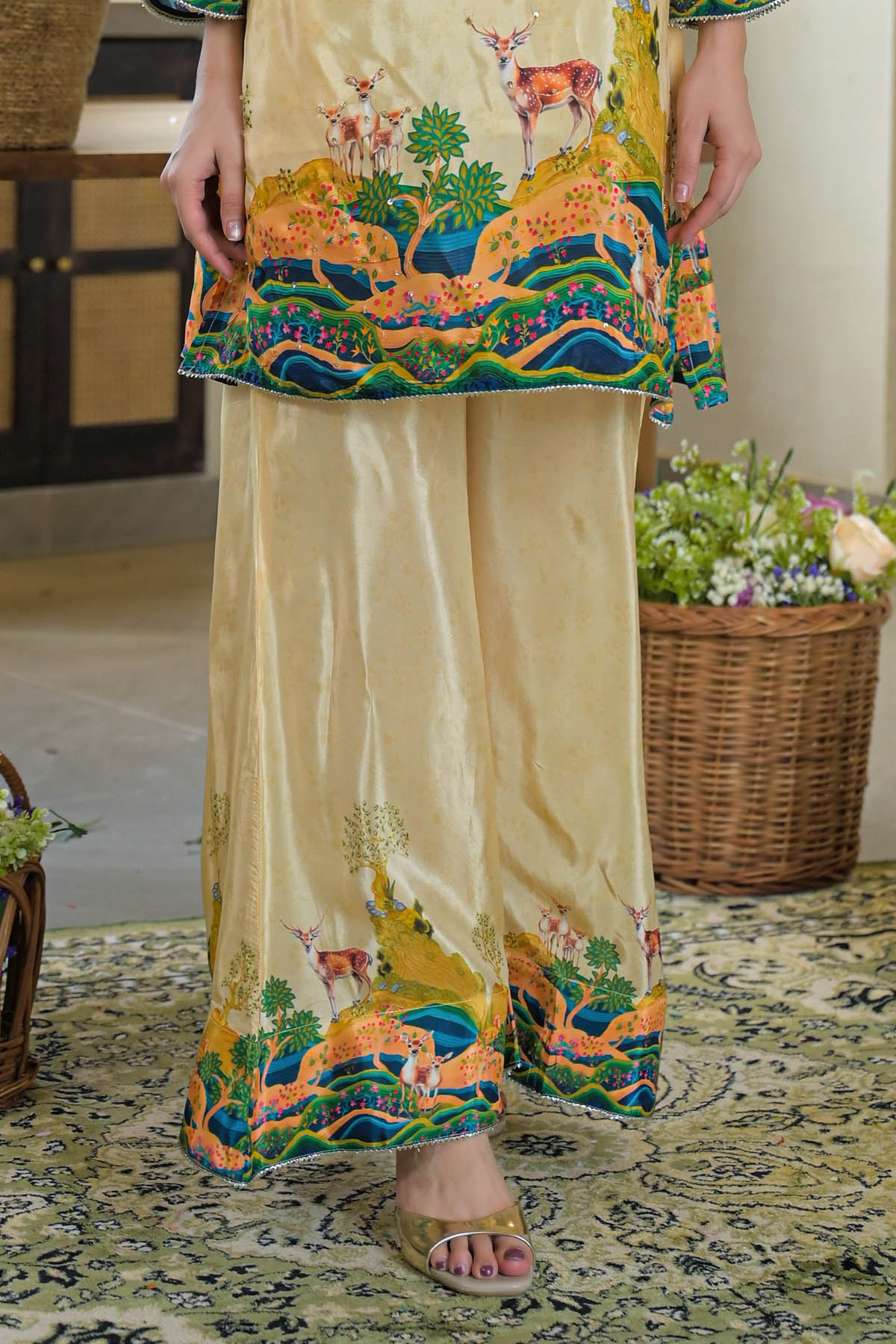 Traditional outfit with a colorful top and beige pants on a patterned rug.