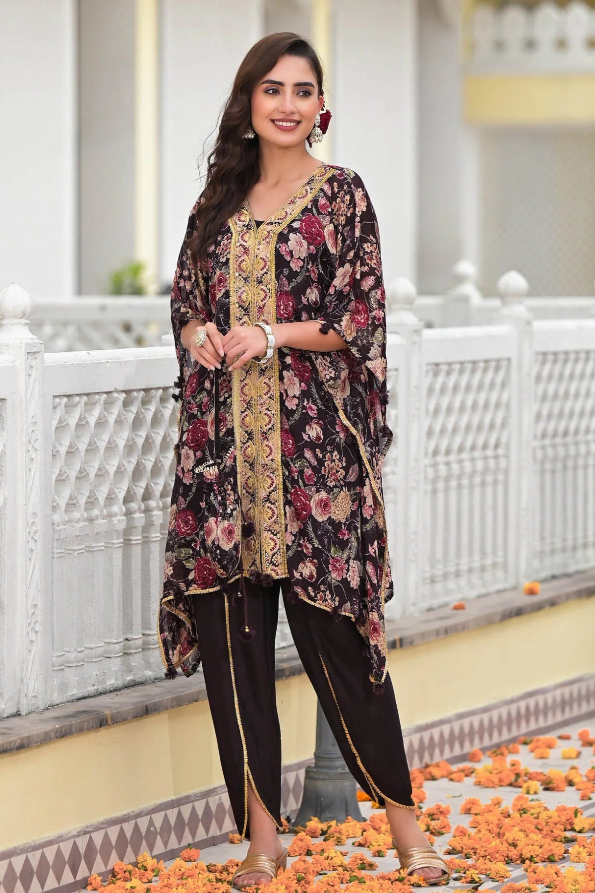 Woman wearing a floral and embroidered traditional outfit standing on a decorative path.