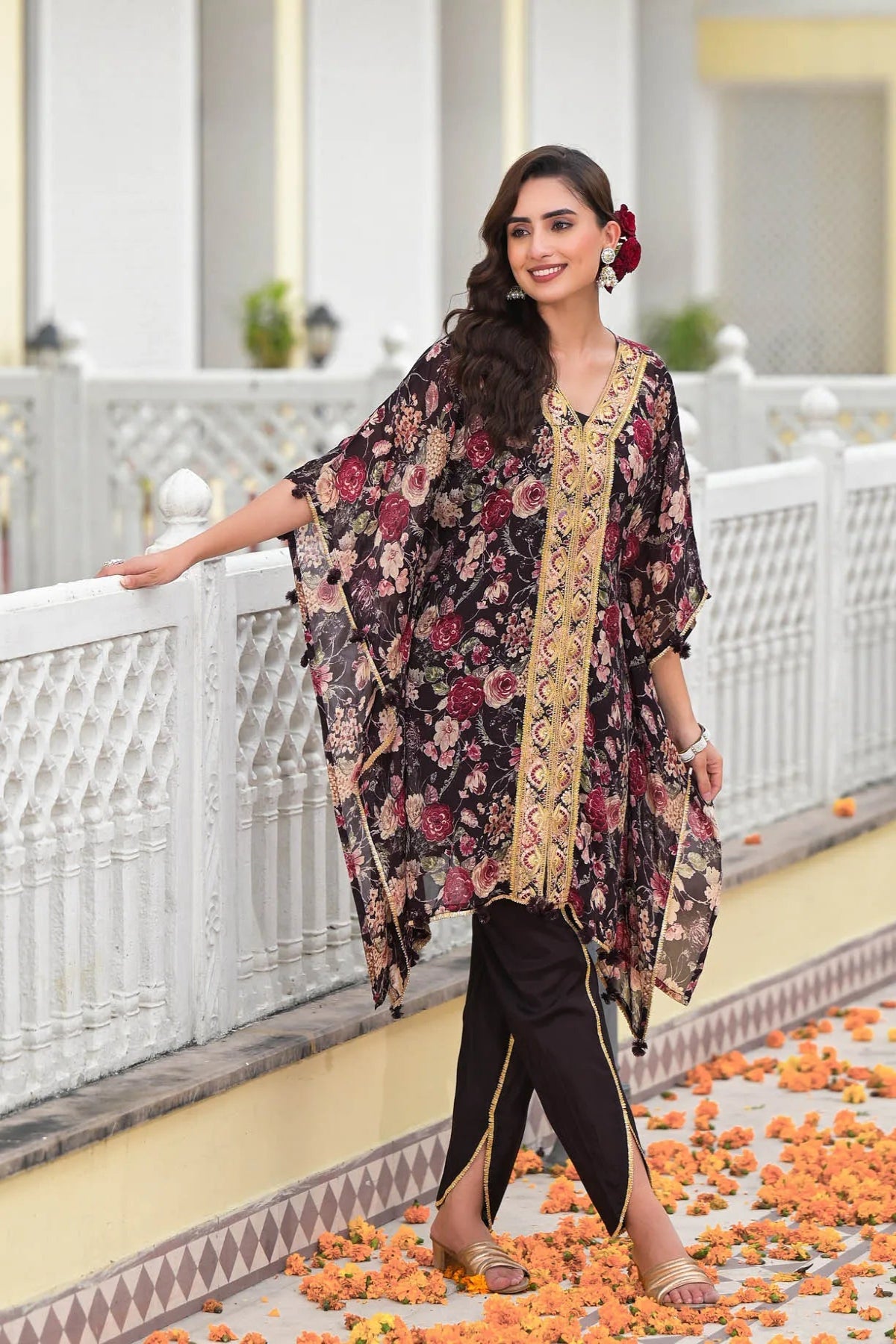 Woman in a floral dress standing on a decorated pathway with flowers.