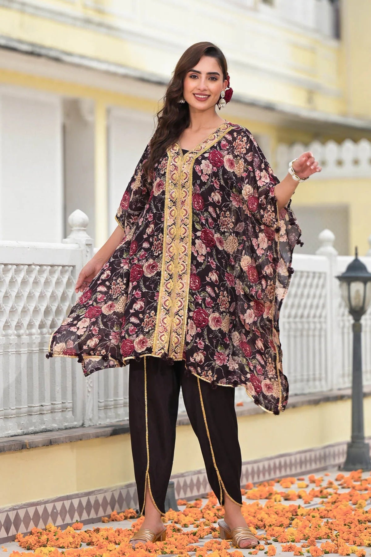 Woman wearing a floral dress with a yellow border on a decorative path.