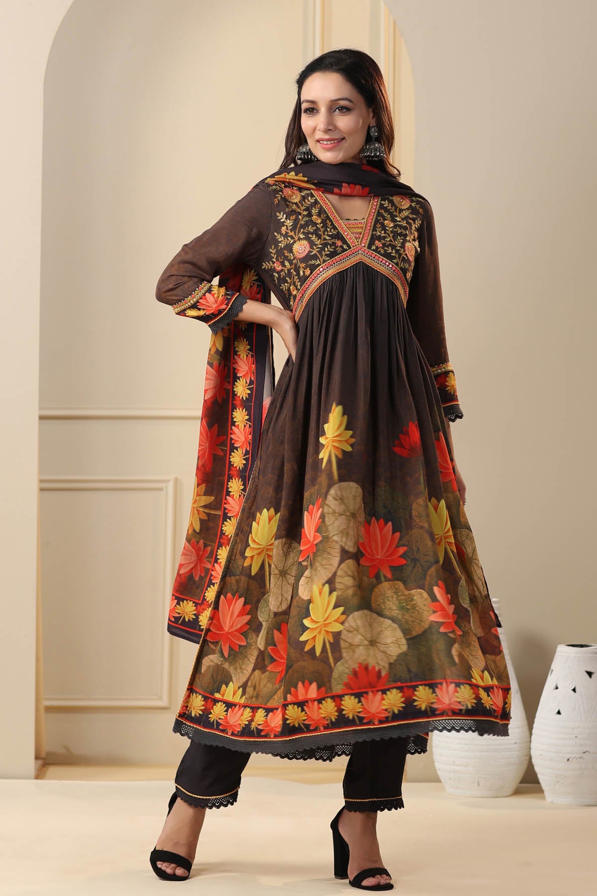 Woman wearing a traditional outfit with floral patterns in a neutral setting