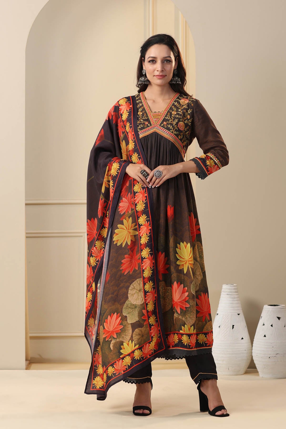 Woman wearing a traditional outfit with floral patterns in a minimalistic setting