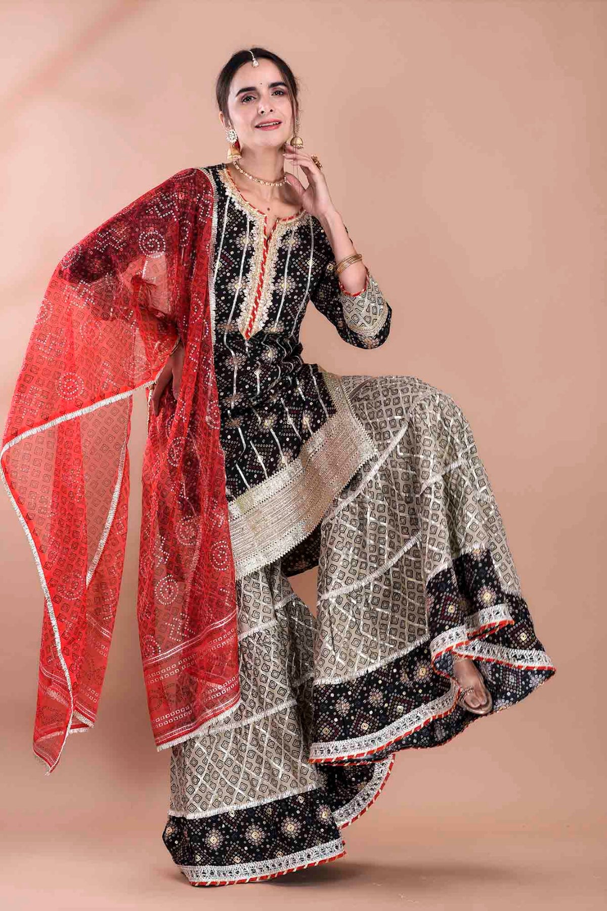 Woman wearing a traditional outfit with a red dupatta on a beige background