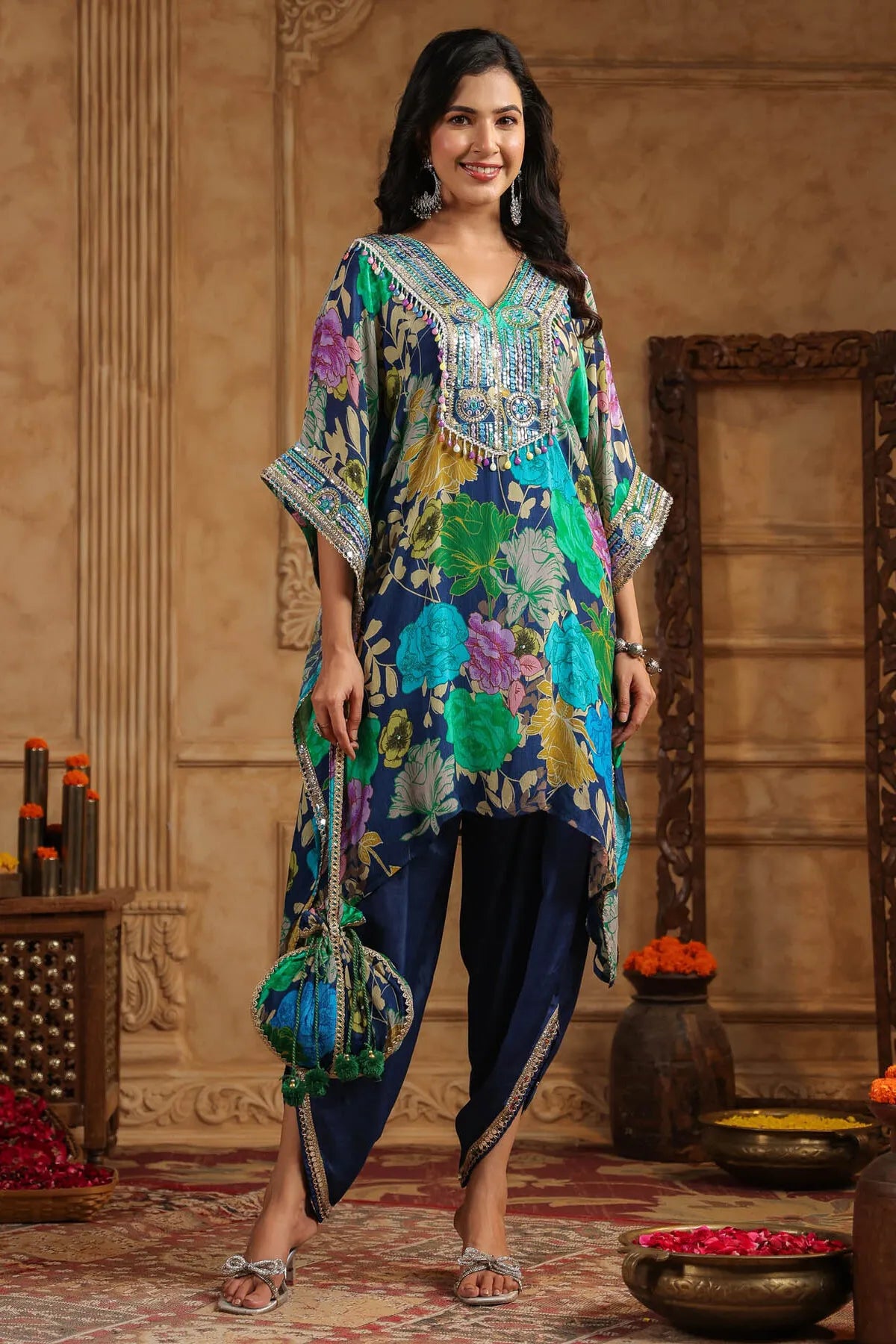 Woman wearing a colorful traditional outfit with a floral design in an ornate room.
