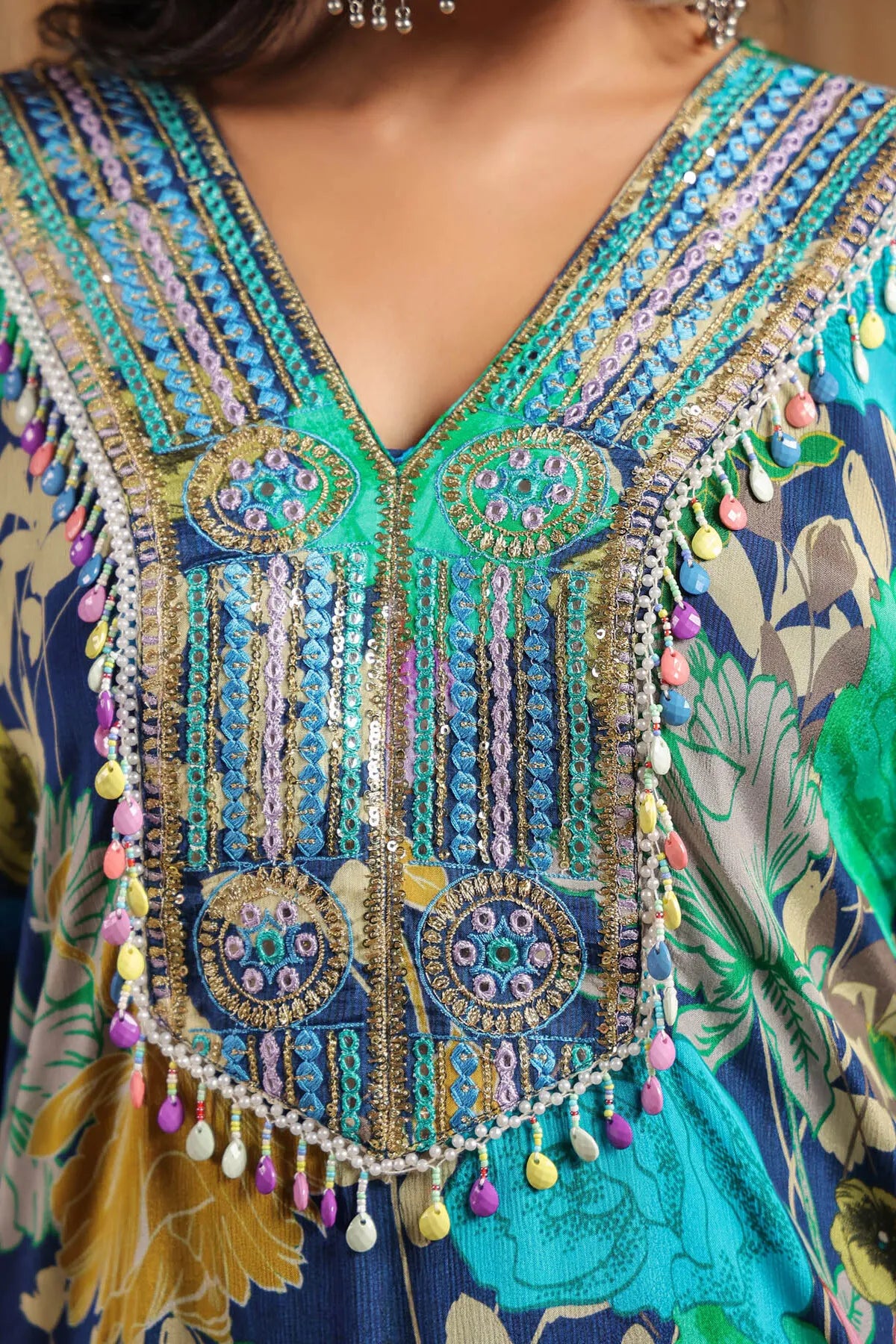 Close-up of a colorful embroidered garment with intricate patterns and beadwork.