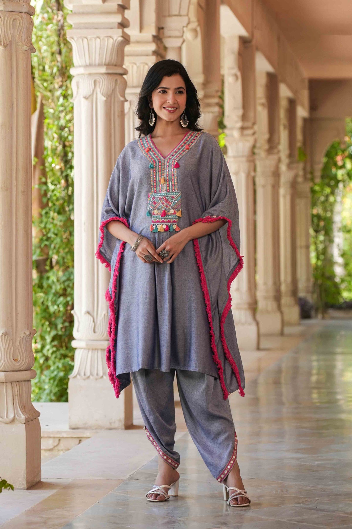 Woman in traditional outfit standing in a decorative outdoor setting