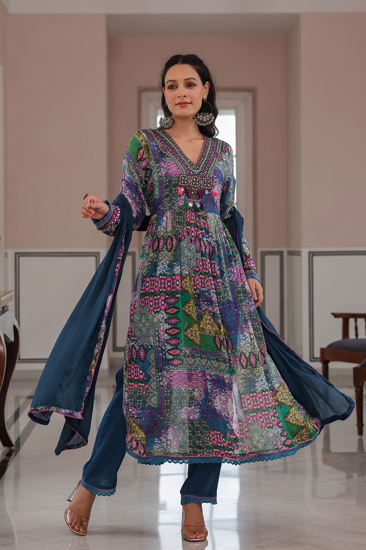 Woman wearing a colorful traditional outfit in a room with neutral decor