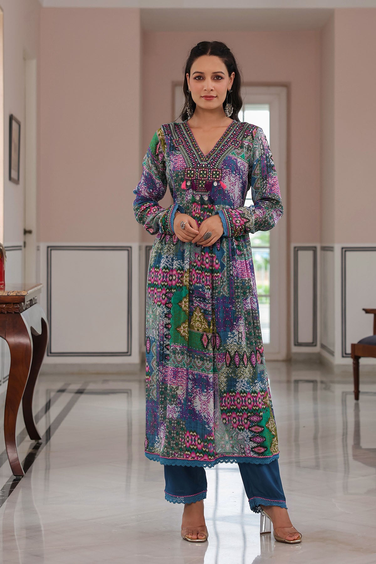 Woman wearing a colorful traditional outfit in a well-lit room.