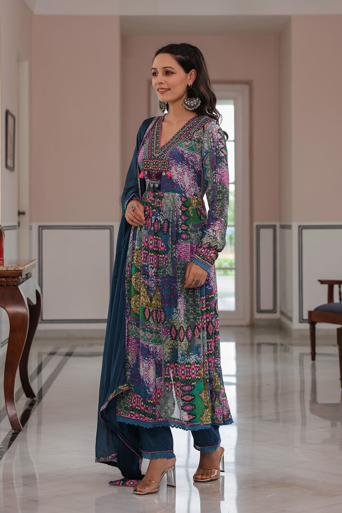 Woman wearing a colorful traditional outfit in a well-lit room.