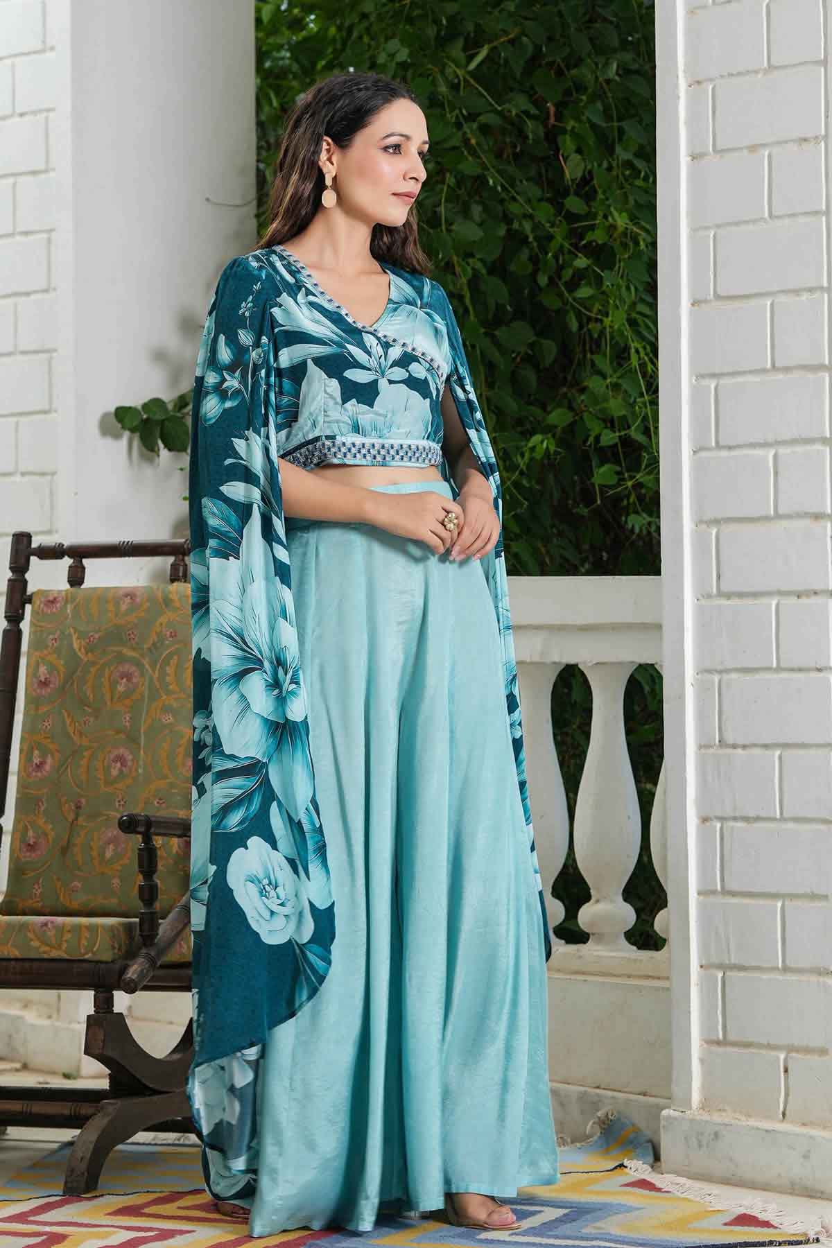 Woman wearing a teal floral dress with a white background