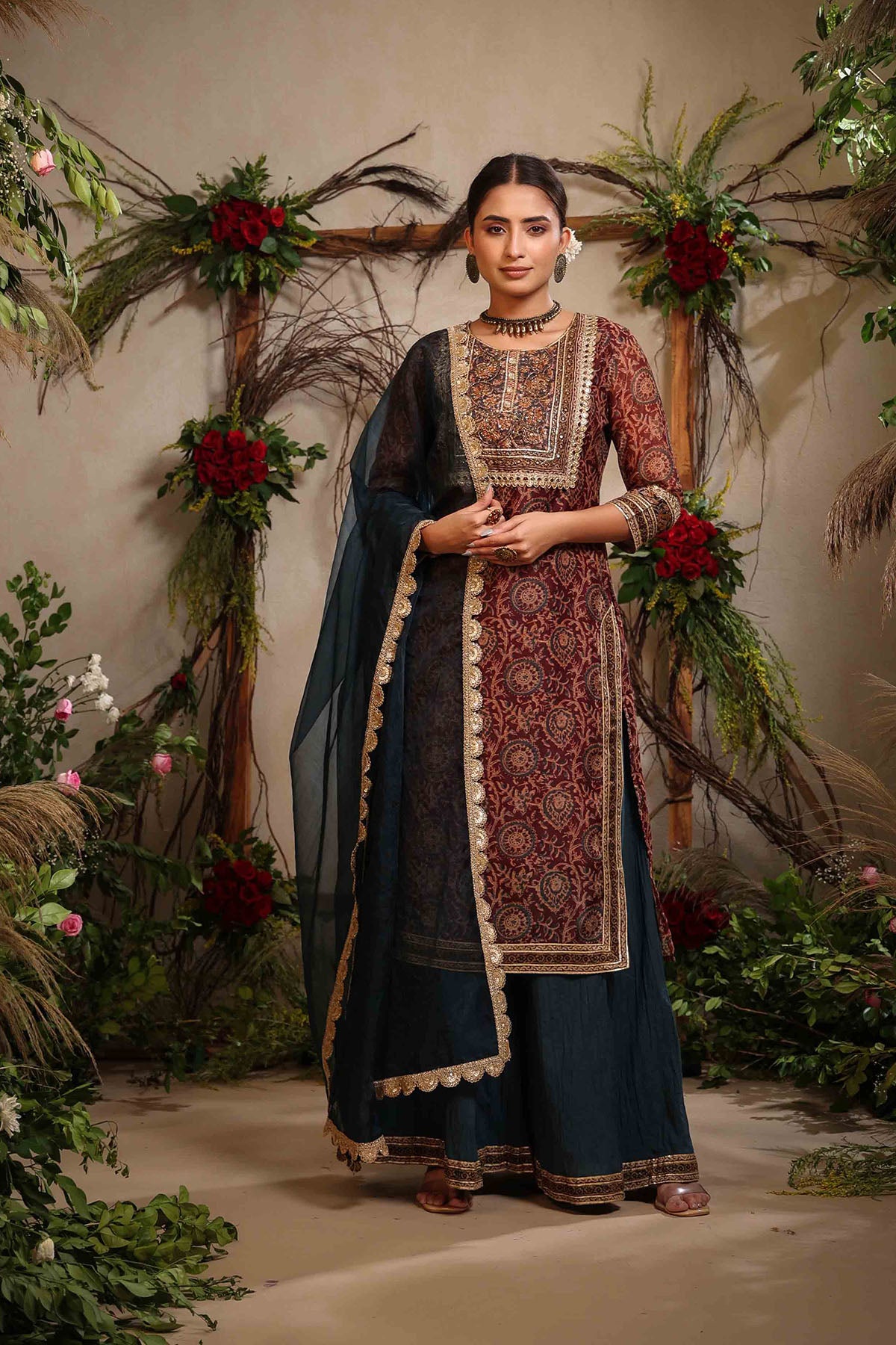 Woman in traditional outfit with floral decorations in the background