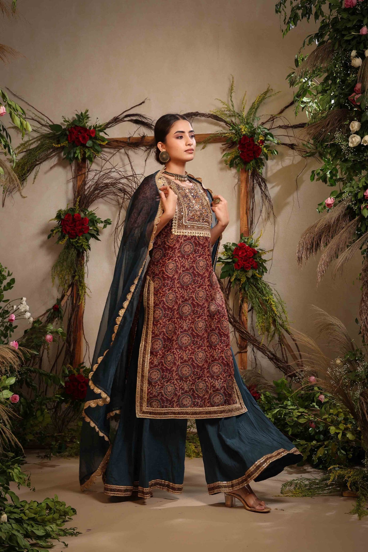 Woman in traditional outfit with floral decorations in the background