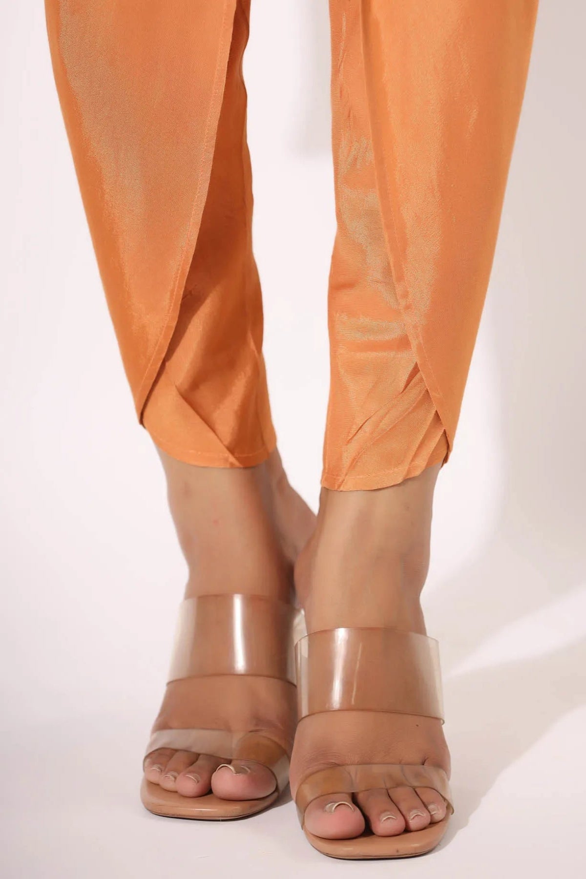 Orange pants and beige sandals on a white background