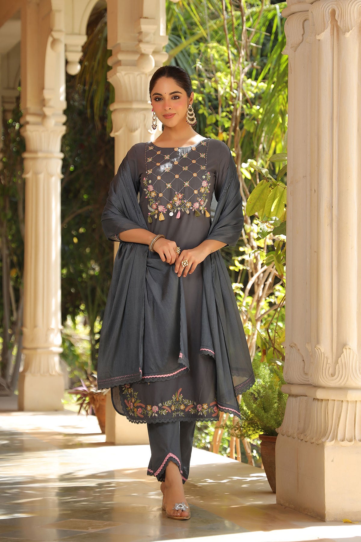 Woman in a traditional outfit standing in a garden setting