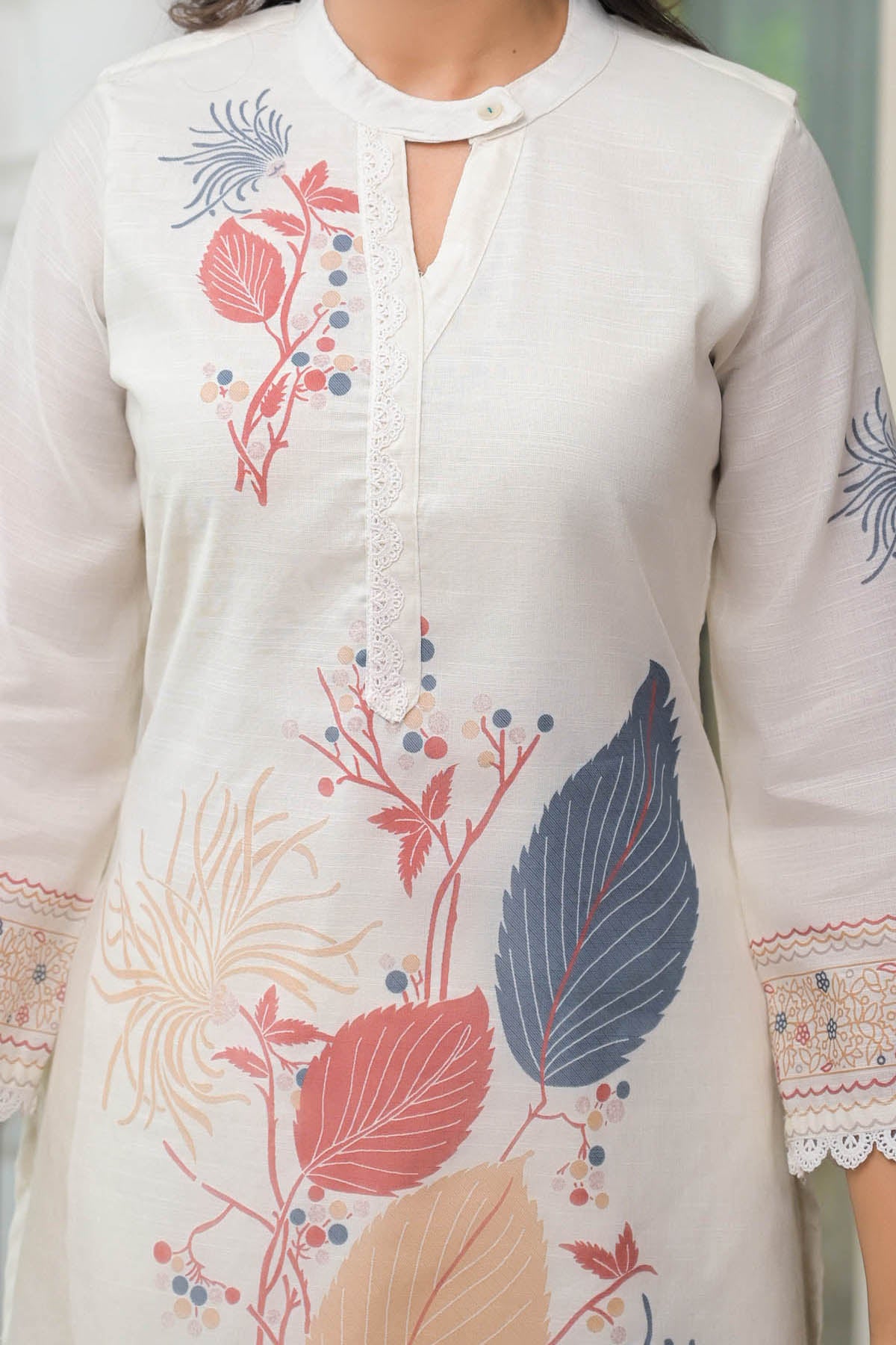 White kurta with colorful floral embroidery on a blurred background