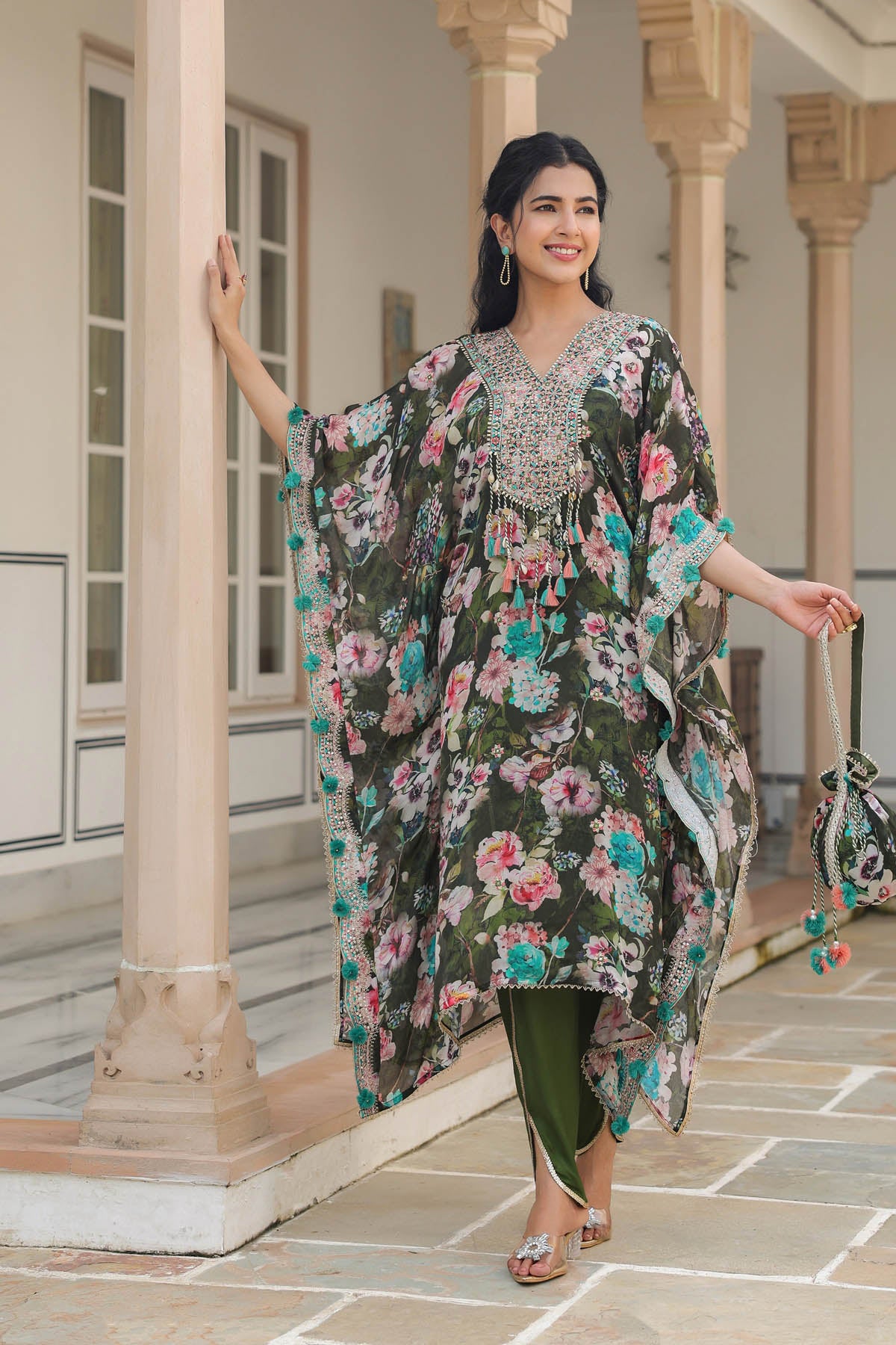 Woman in a floral dress standing in a courtyard with columns.