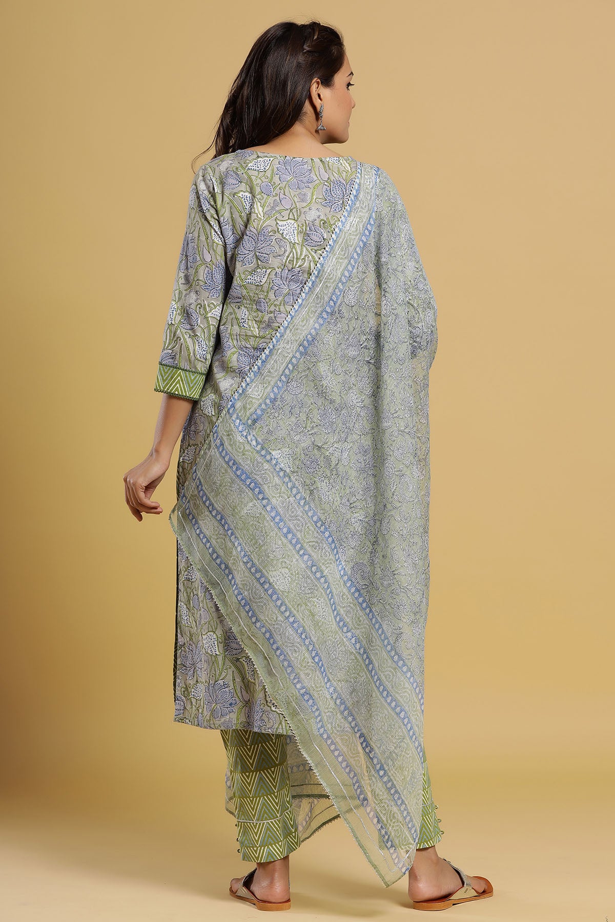 Woman wearing a patterned outfit with a beige background