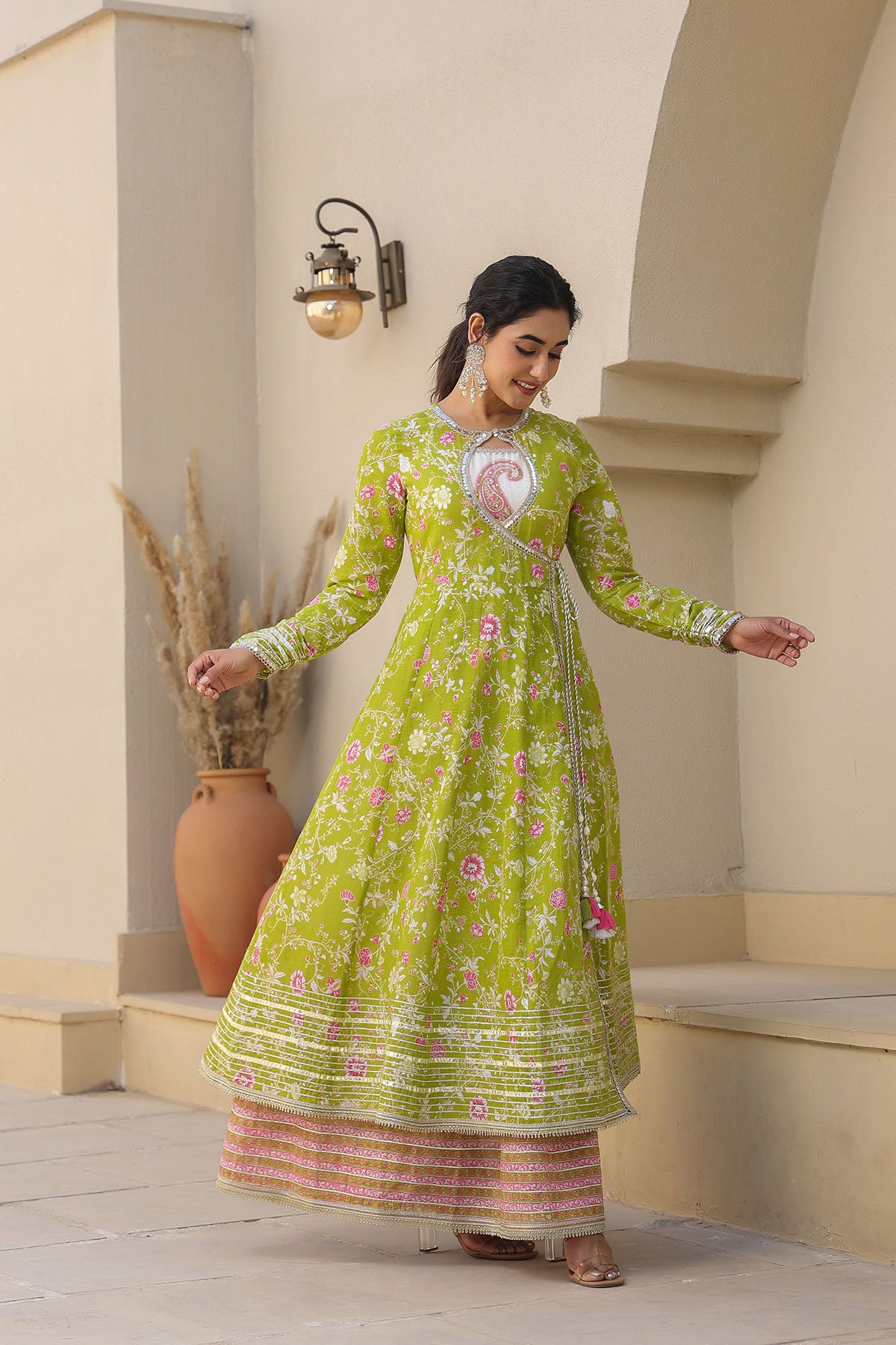 Woman wearing a green floral dress standing in an outdoor setting.