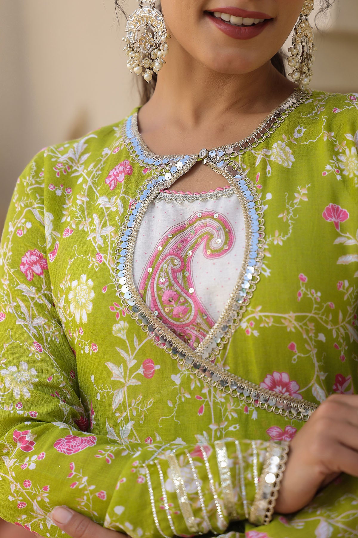 Green embroidered traditional outfit with pink floral patterns
