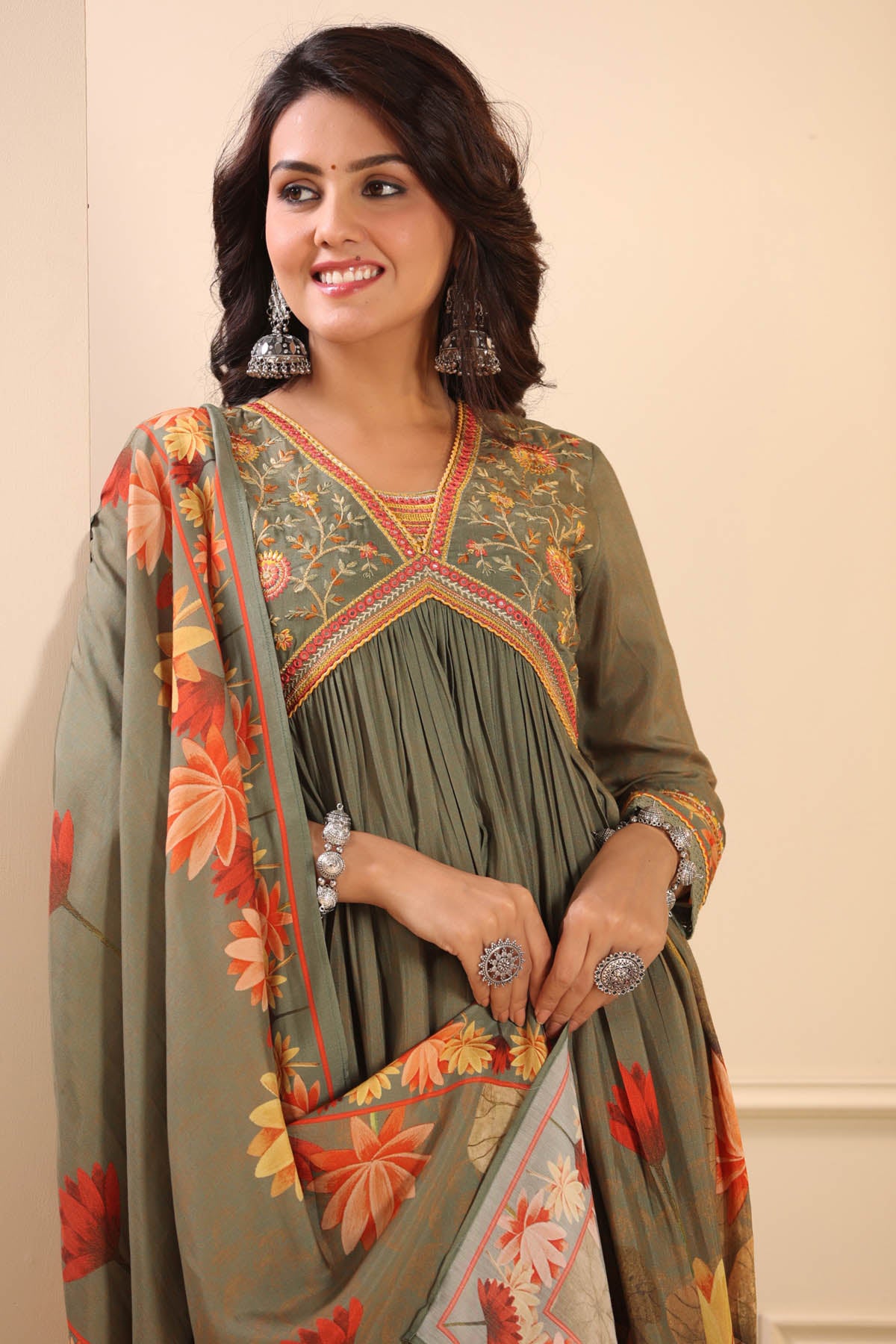 Woman wearing a green floral dress with a beige background