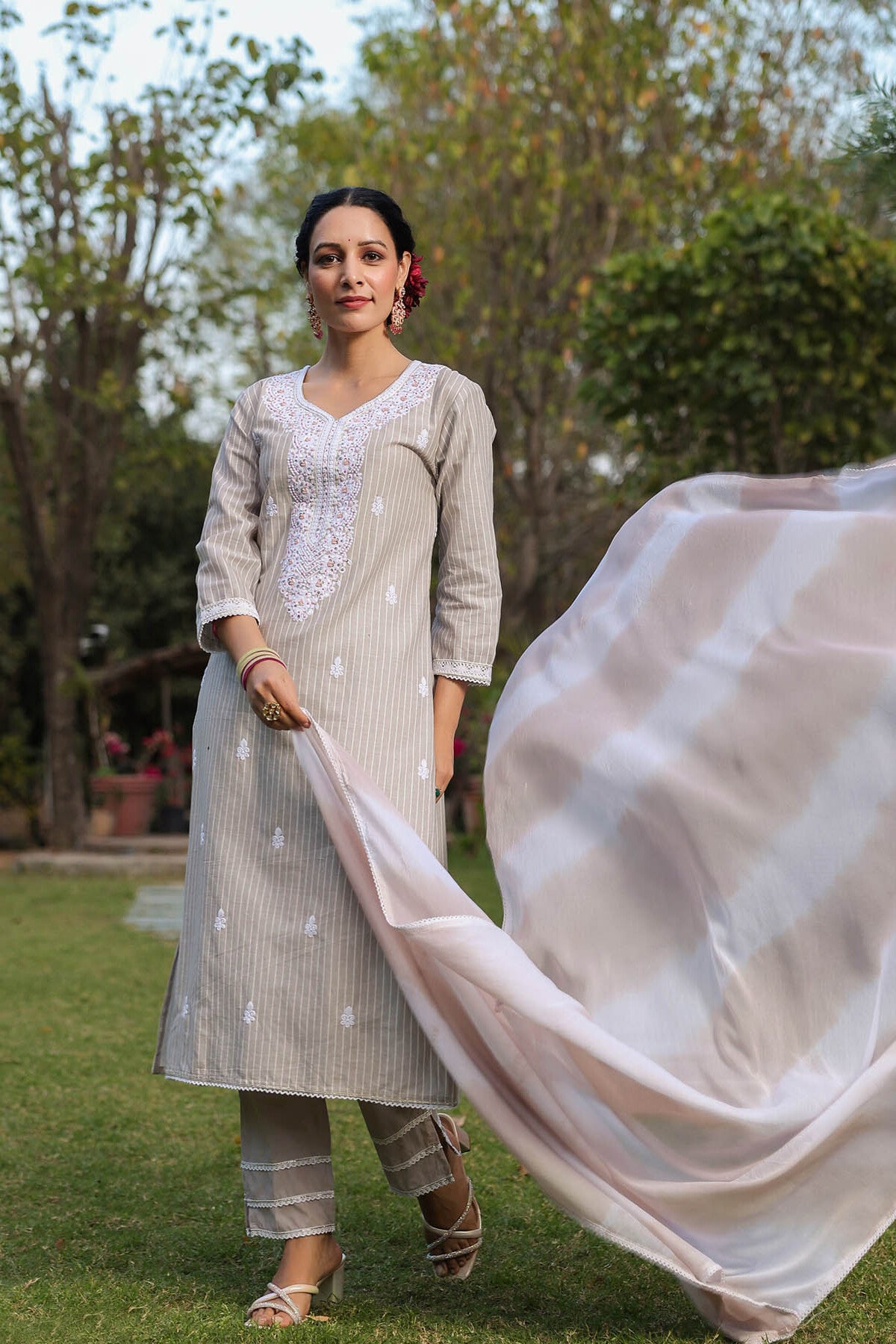 Woman in traditional outfit with a flowing fabric in an outdoor setting