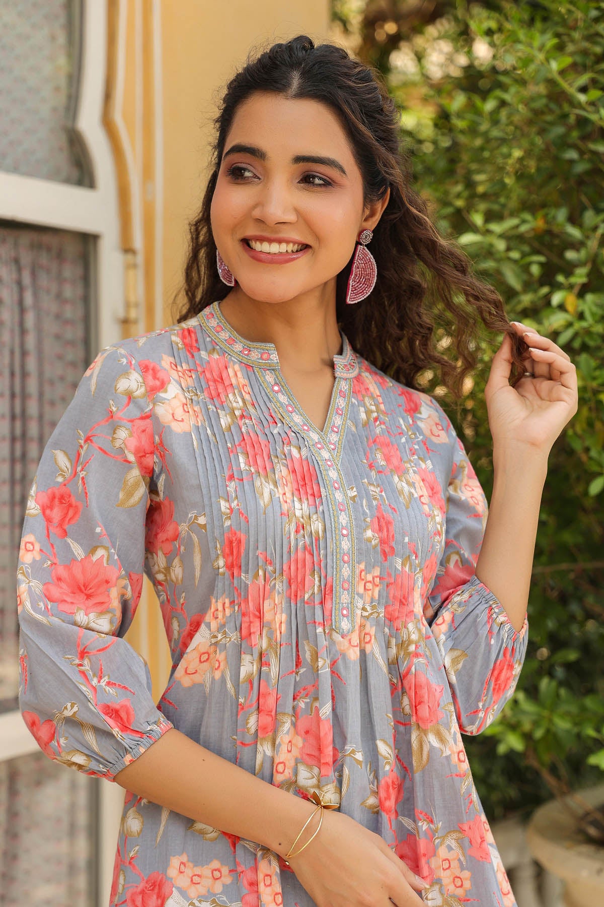 Woman wearing a floral dress with a blurred outdoor background
