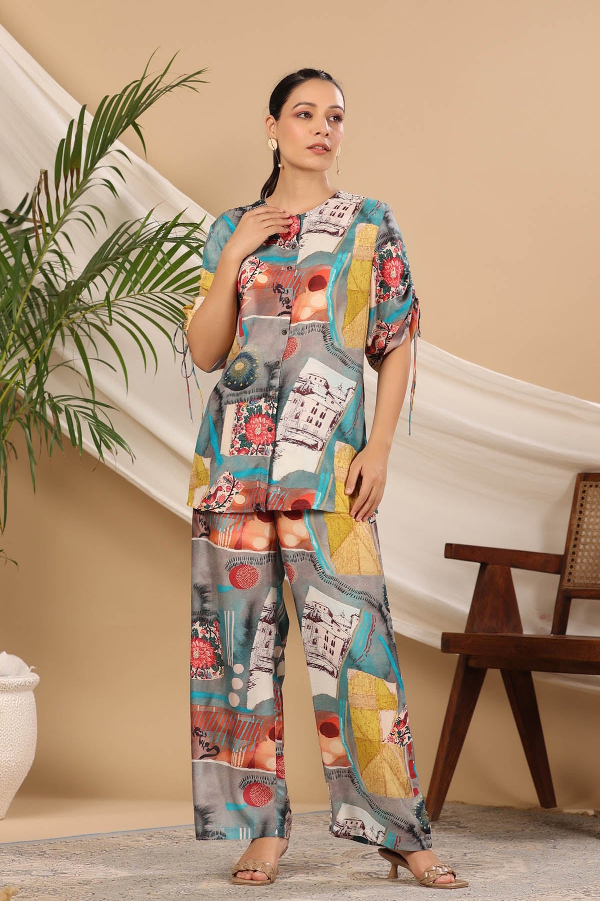 Woman wearing a colorful outfit with a pattern of various images, standing indoors.