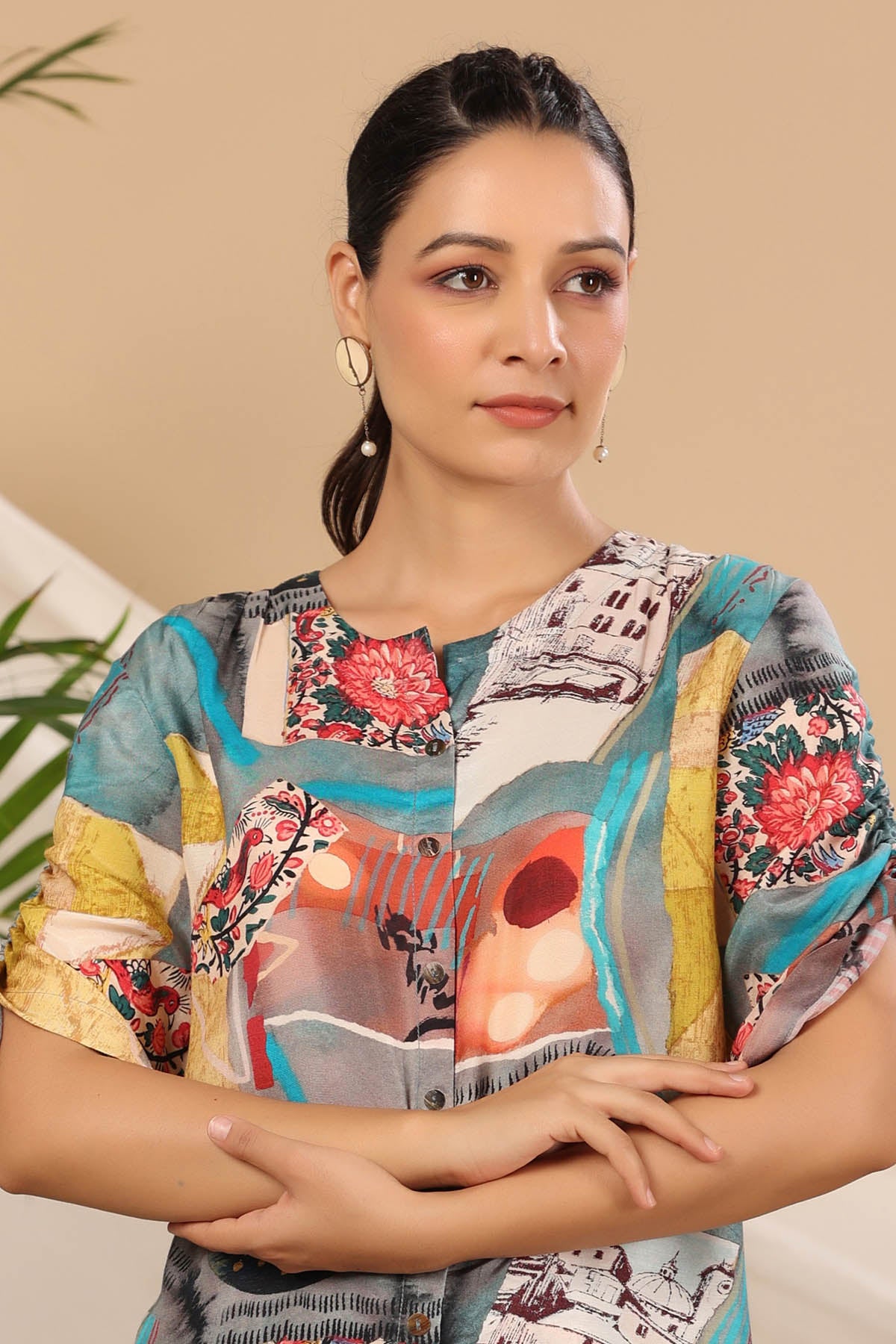 Woman wearing a colorful patterned shirt with a neutral background