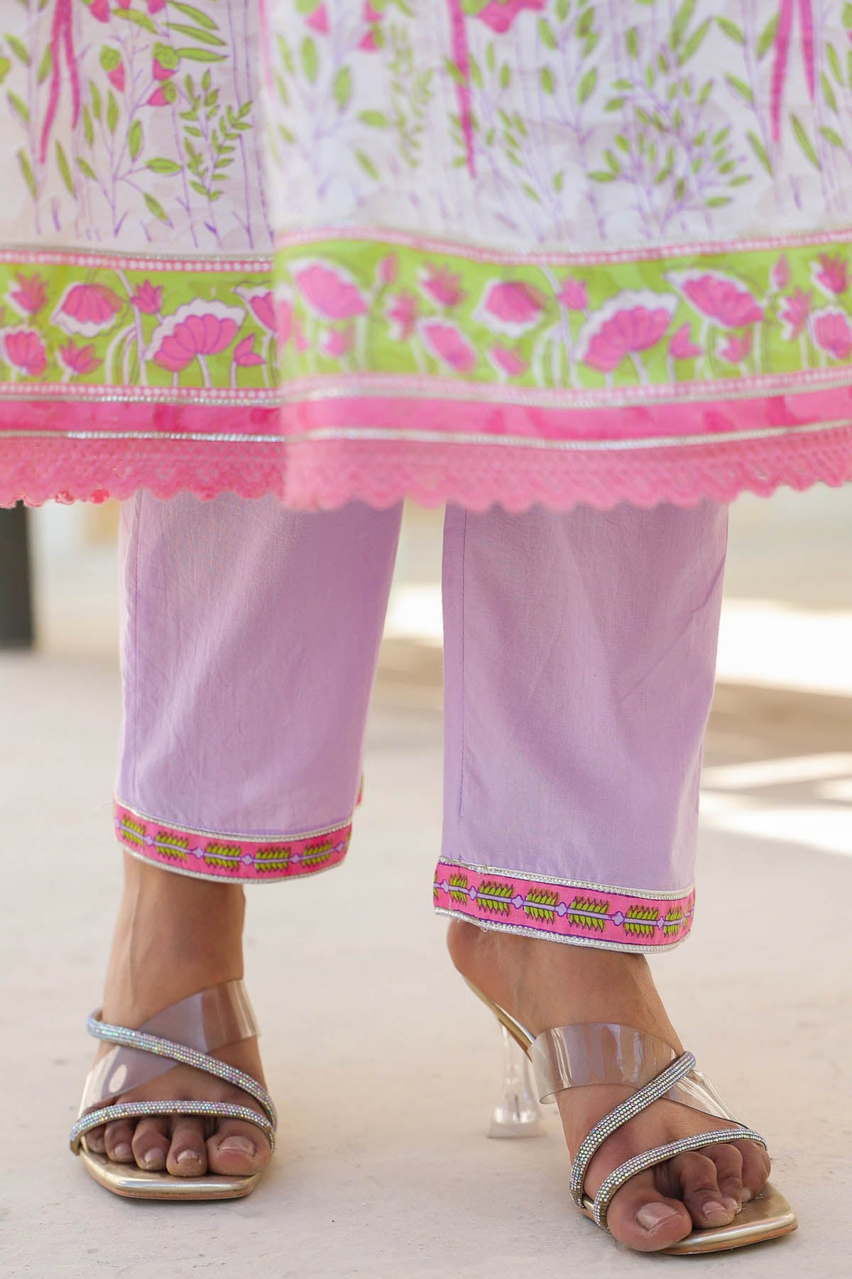 Traditional outfit with pink and green patterns on a light background