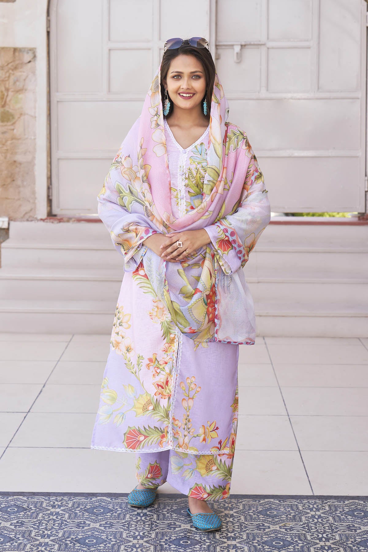 Woman wearing a floral outfit with a matching shawl in an outdoor setting.