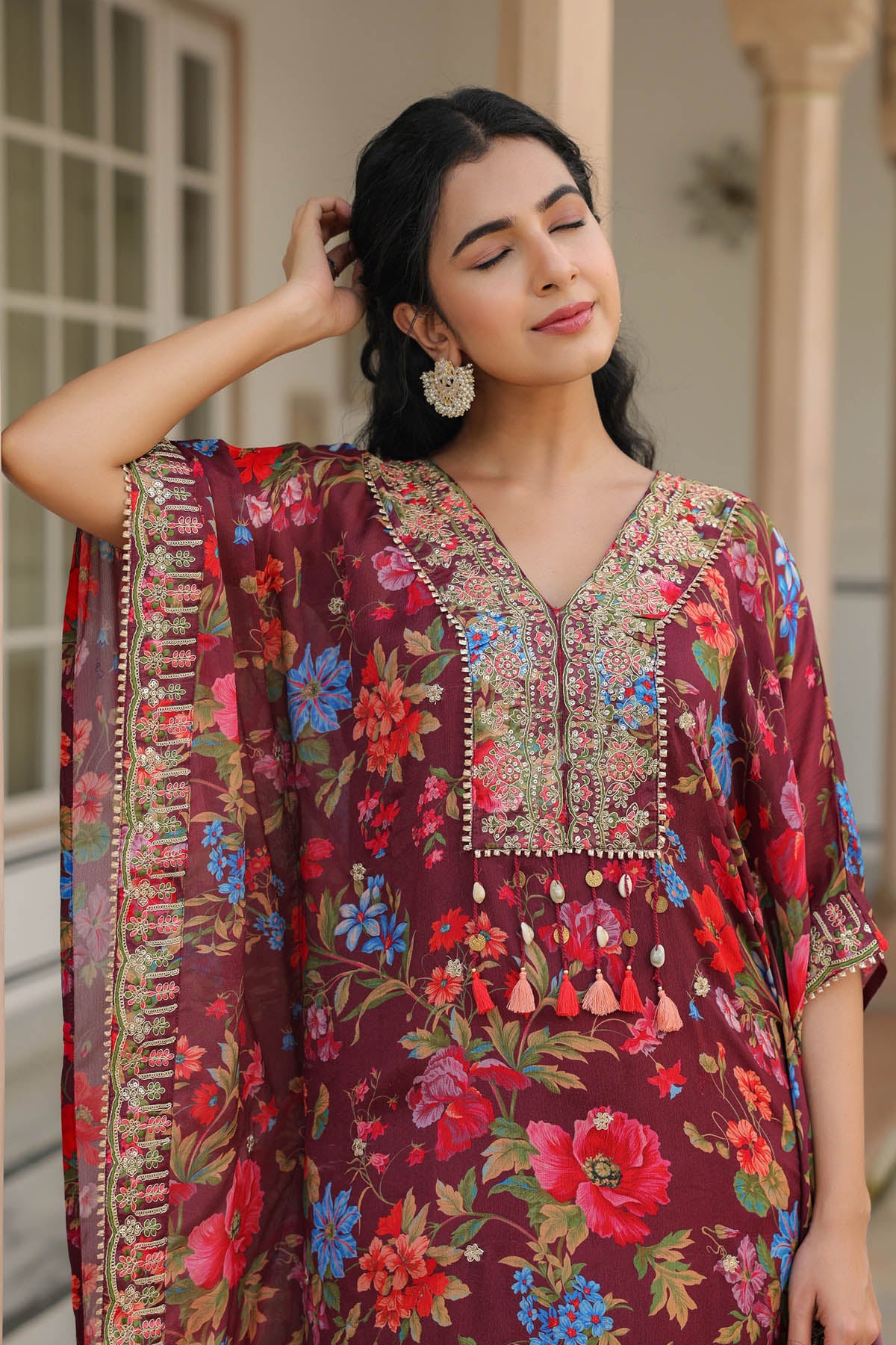 Woman wearing a colorful floral and embroidered traditional outfit.
