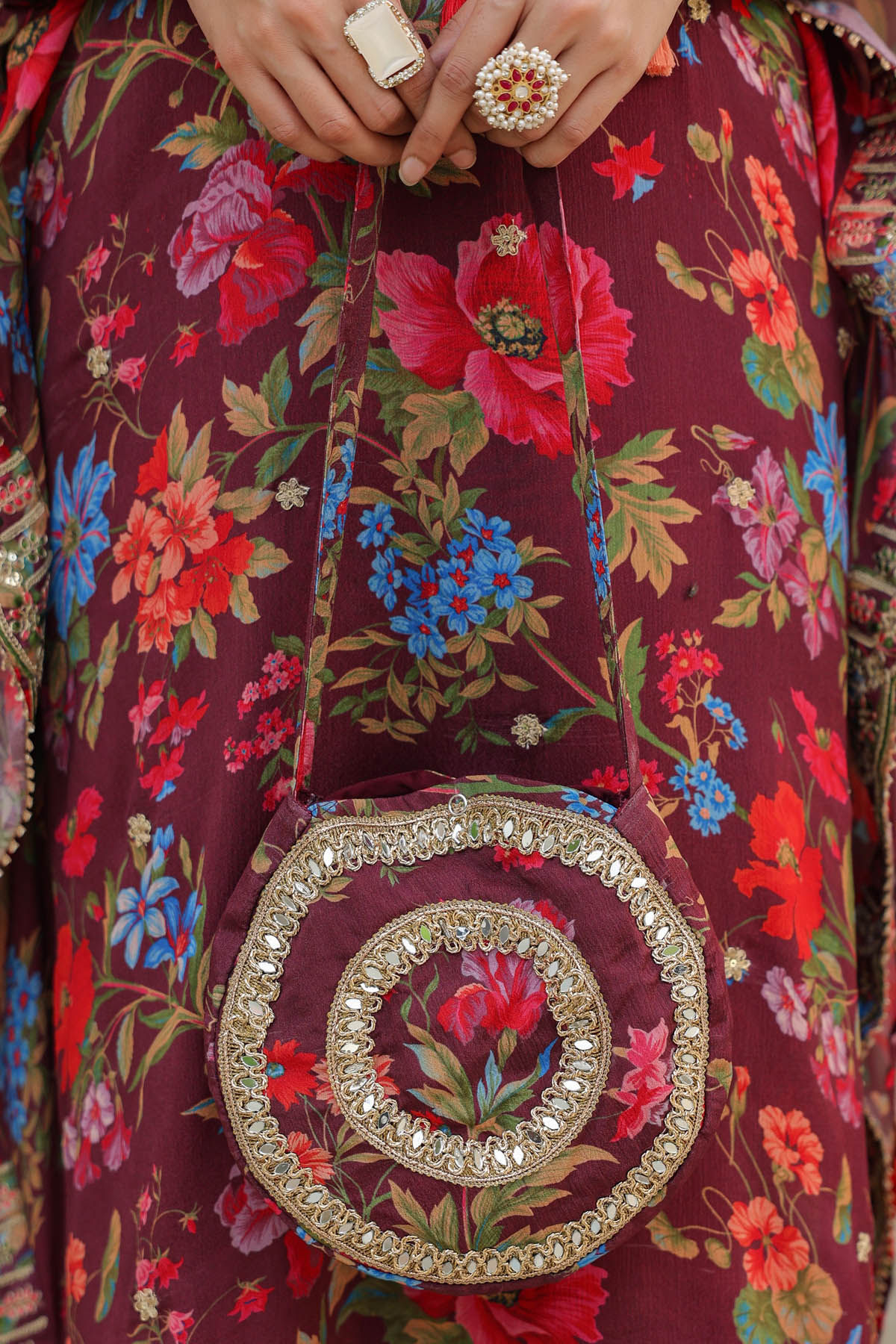 Close-up of a person wearing a floral dress with a decorative belt buckle.