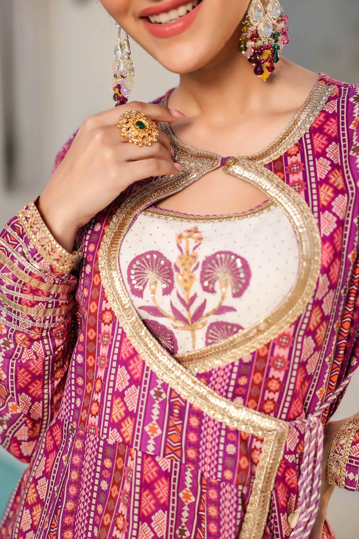 Woman wearing a traditional outfit with intricate patterns and jewelry.