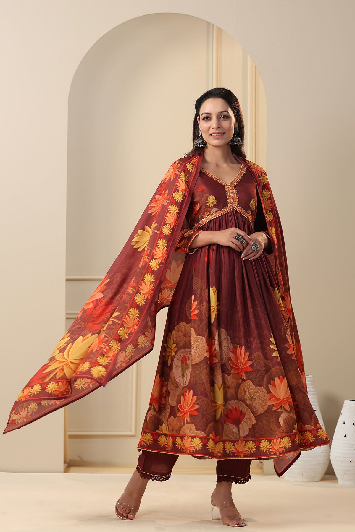 Woman wearing a traditional outfit with a floral shawl in a neutral setting