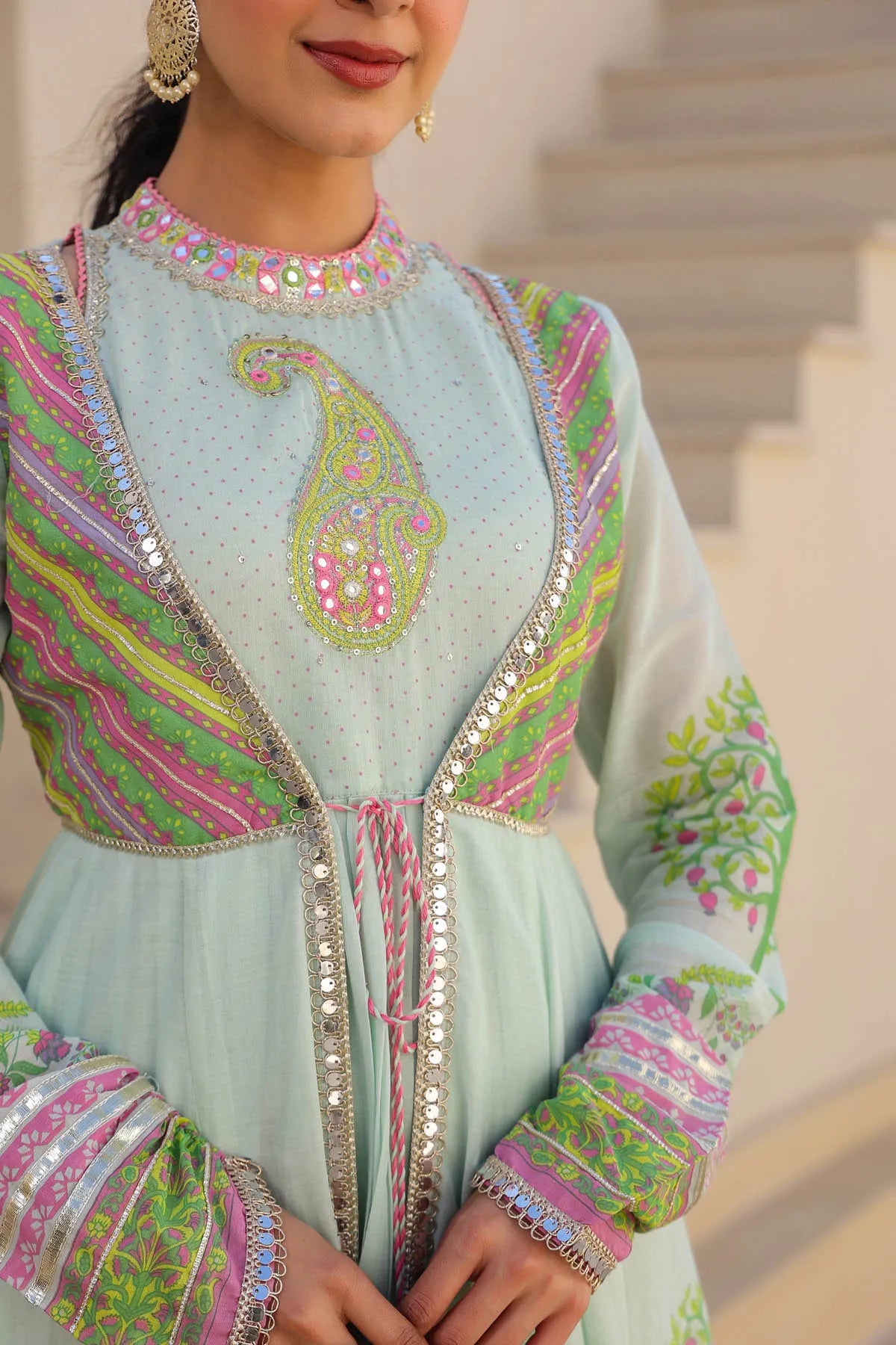 Light blue embroidered traditional outfit with pink and green patterns.