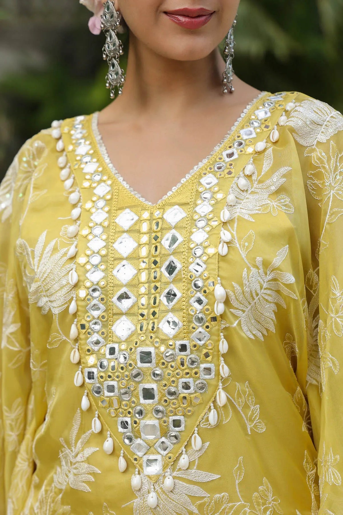 Yellow embroidered dress with silver details worn by a person.