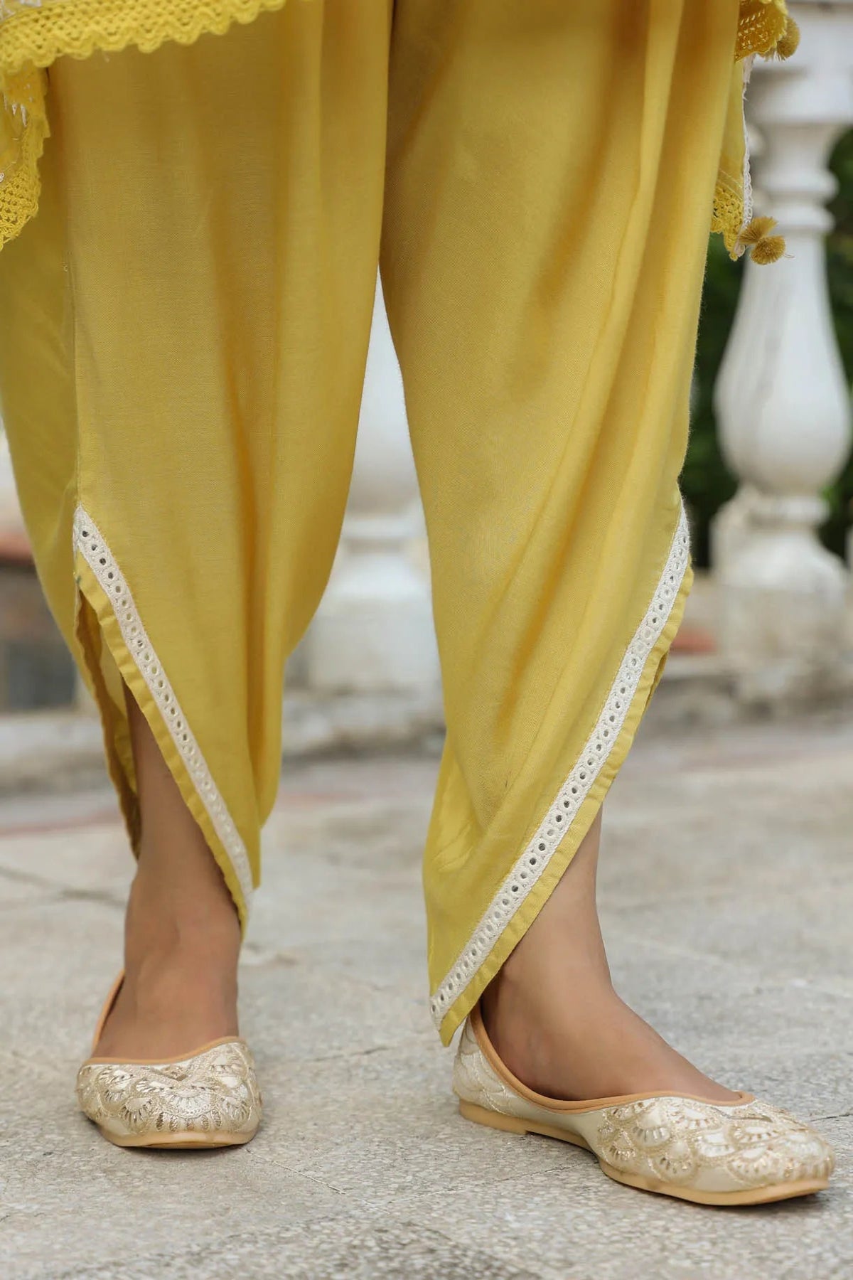 Yellow traditional outfit with gold shoes on a blurred background