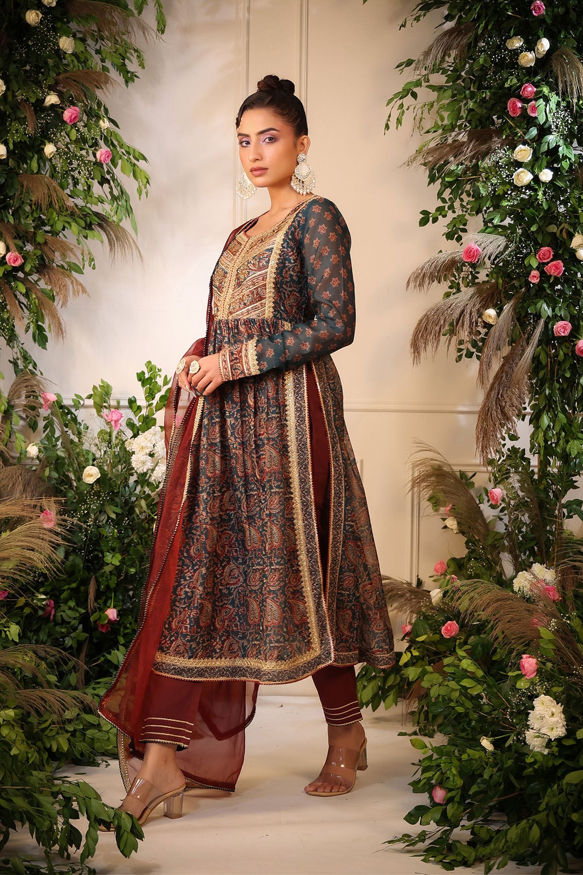 Woman in traditional outfit standing amidst floral decorations
