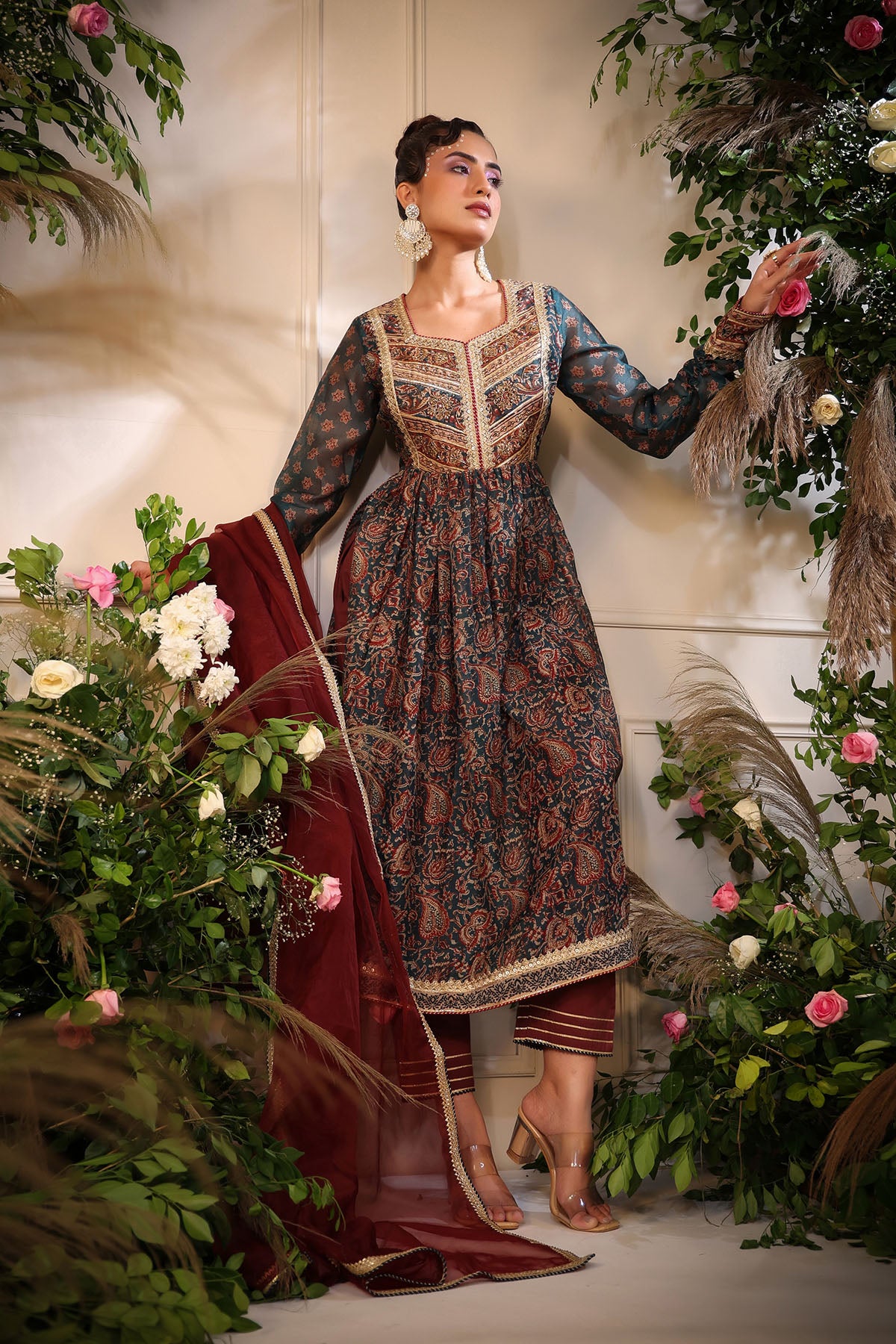 Woman in a traditional outfit surrounded by floral decorations