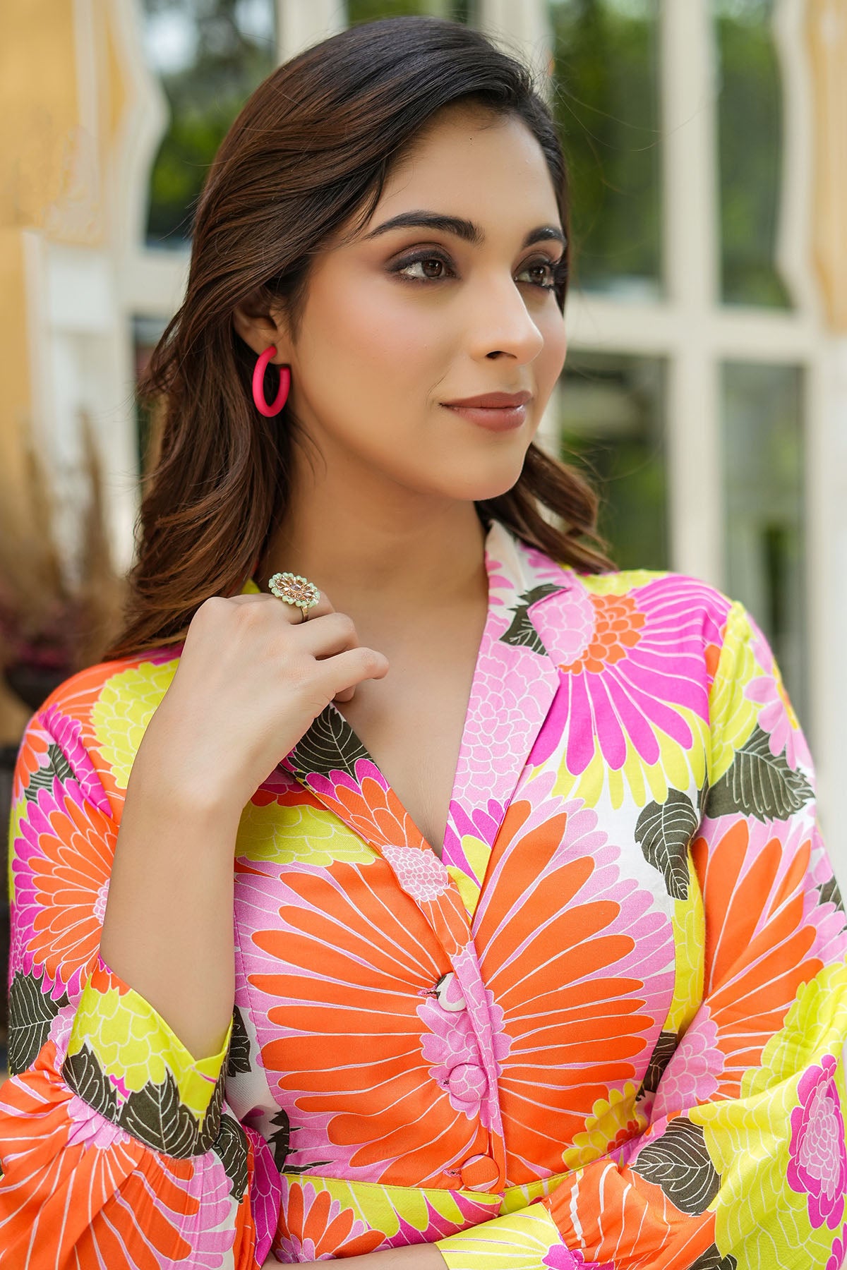 Woman wearing a colorful floral dress with a blurred outdoor background