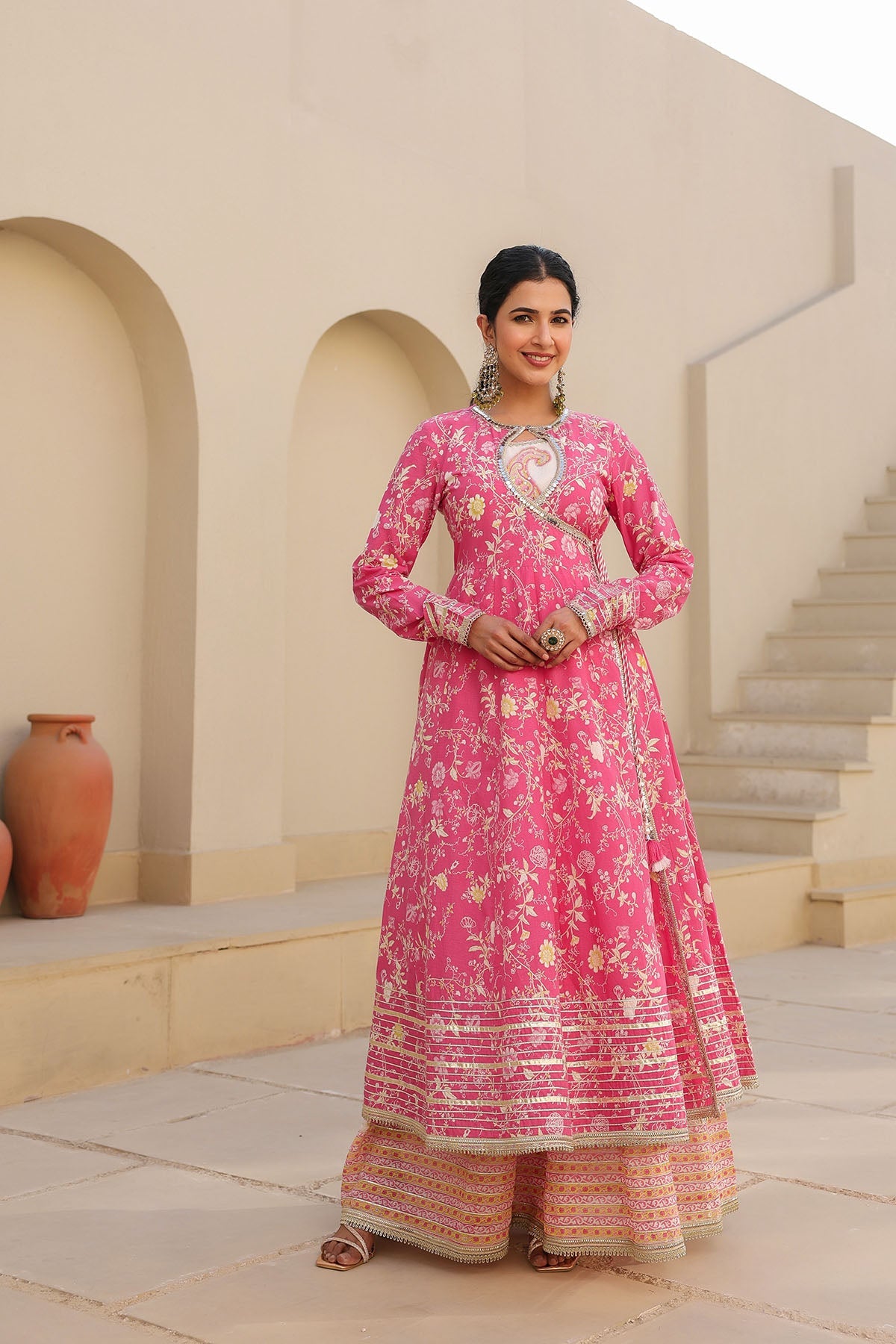 Woman in a pink traditional outfit standing in an architectural setting