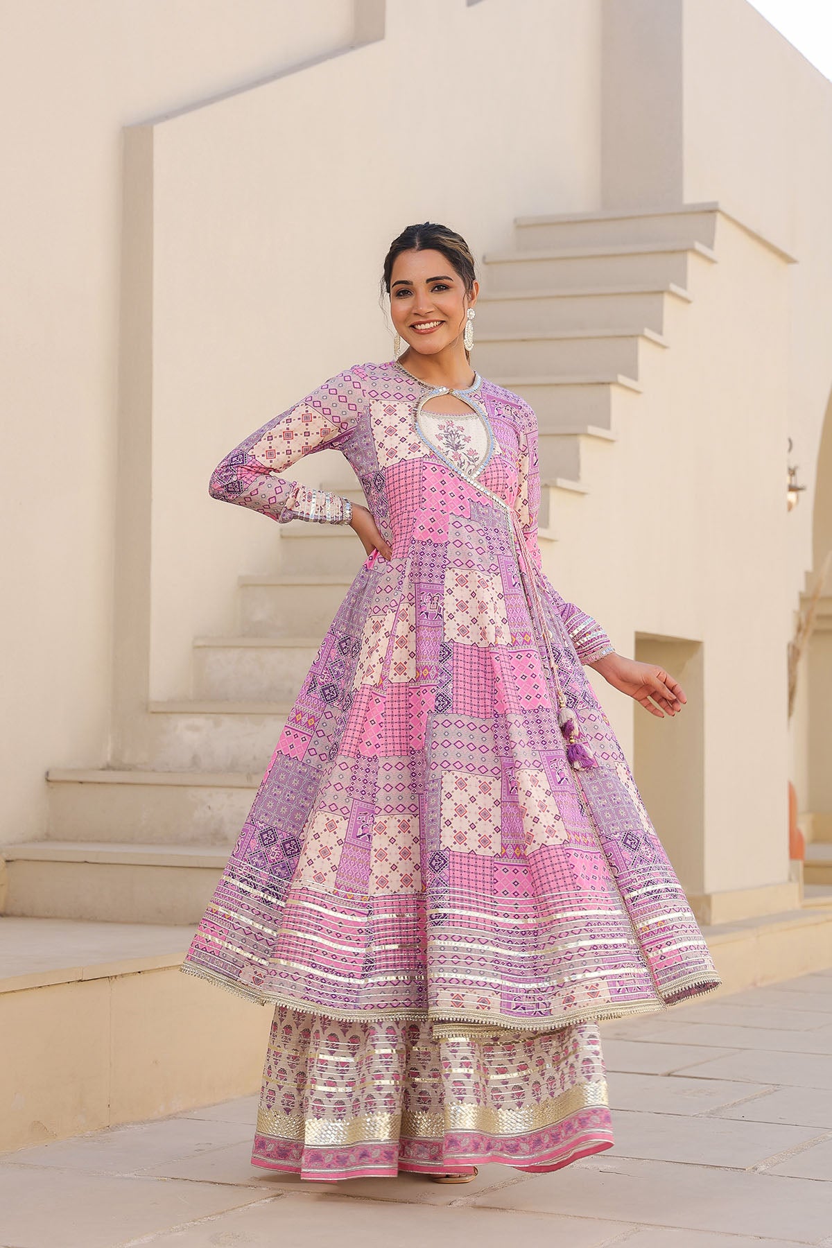 Woman wearing a colorful patterned dress standing outdoors.