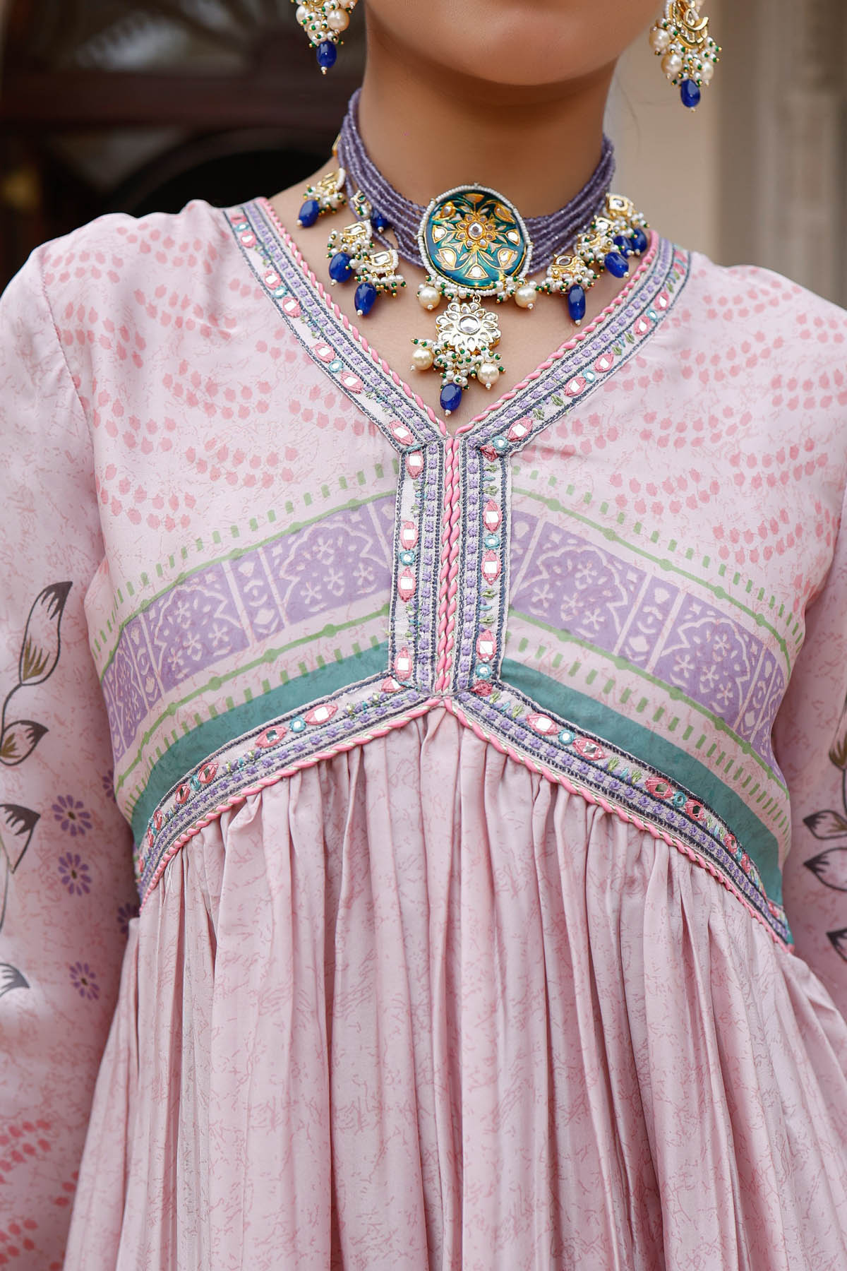 Traditional outfit with intricate embroidery and a decorative necklace.