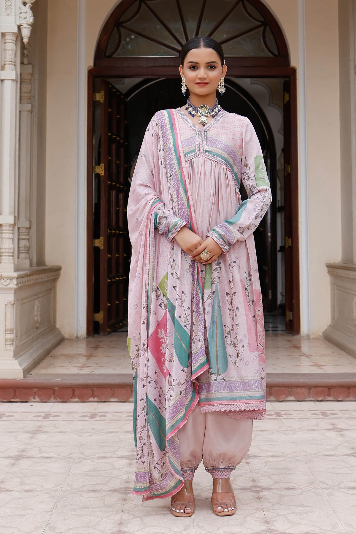 Woman in a traditional outfit standing in front of an archway