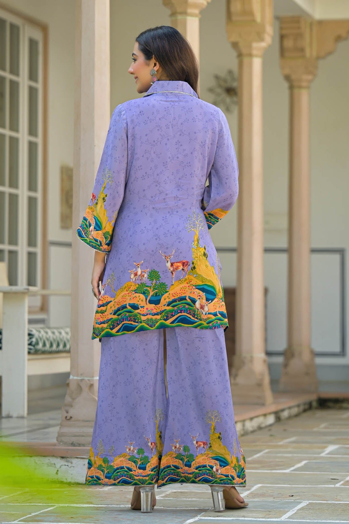 Woman wearing a purple traditional outfit with colorful embroidery in an outdoor setting.
