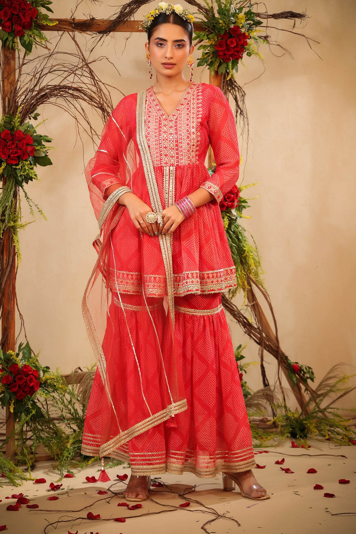 Woman in a red traditional outfit with floral decorations in the background