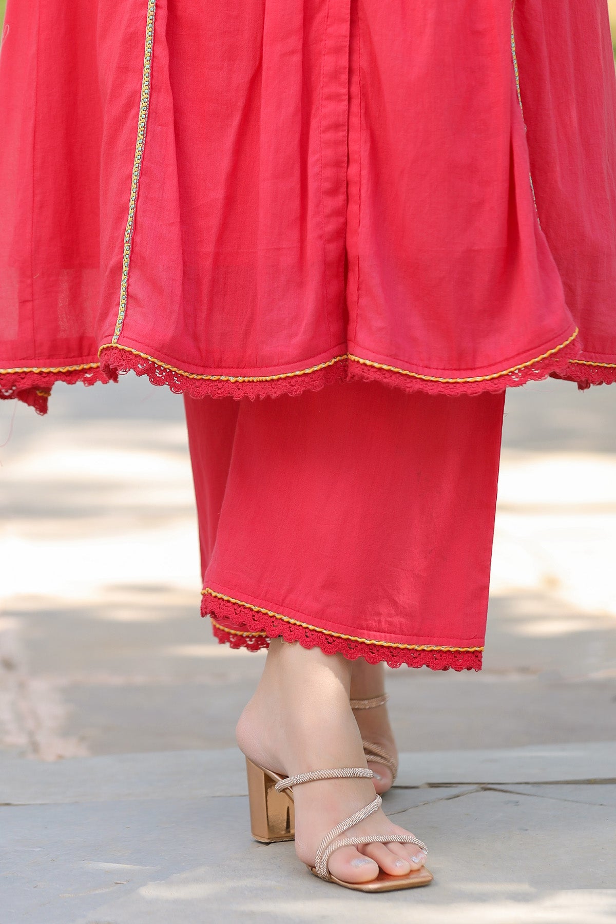 Close-up of a bright pink traditional outfit with gold trim on a blurred background
