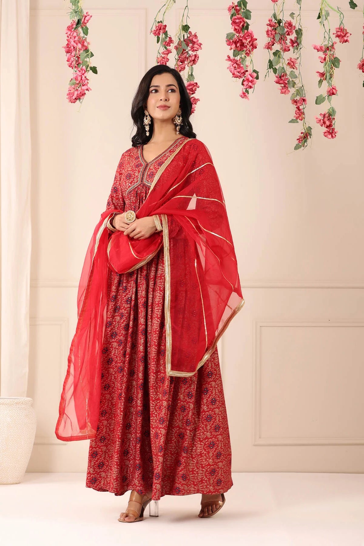 Woman in a red traditional outfit with a floral background
