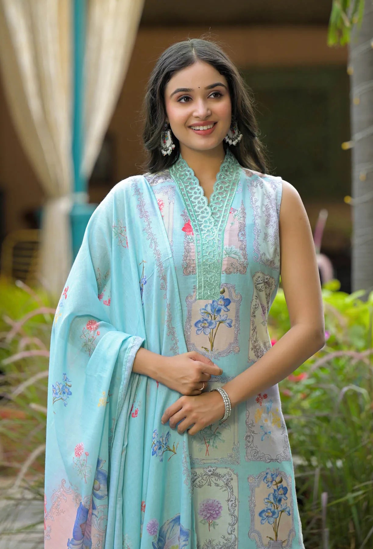 Woman wearing a light blue floral dress with a matching dupatta outdoors.